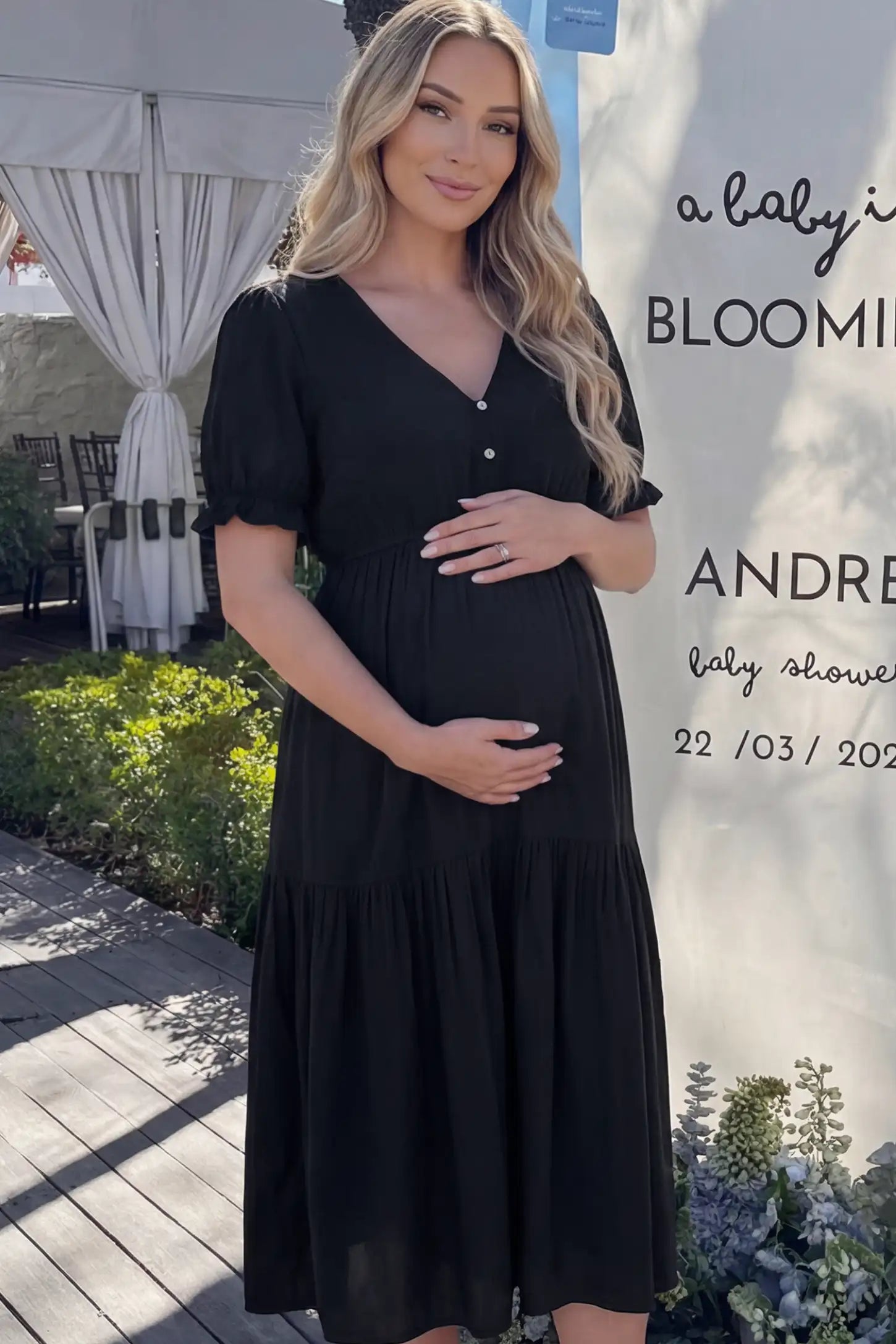 Tiered Hem A-Line Maternity Midi Dress  Tiered Hem A-Line Maternity Midi Dress in black featuring empire waist, elbow-length puff sleeves, V-neckline, and flowy skirt on pregnant model.