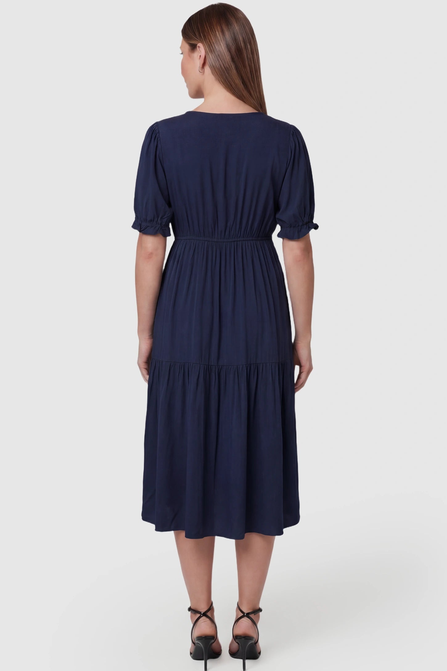 Tiered Hem A-Line Maternity Midi Dress  Tiered Hem A-Line Maternity Midi Dress in navy blue featuring empire waist, elbow-length puff sleeves, V-neckline, and flowy skirt on pregnant model.  back view