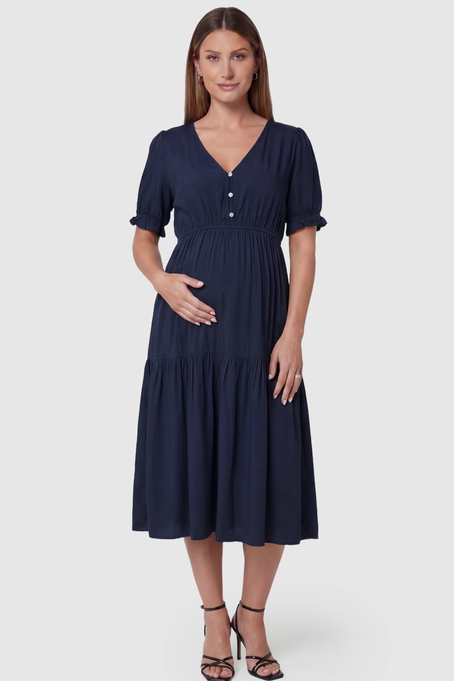 Tiered Hem A-Line Maternity Midi Dress  Tiered Hem A-Line Maternity Midi Dress in navy blue featuring empire waist, elbow-length puff sleeves, V-neckline, and flowy skirt on pregnant model. front view