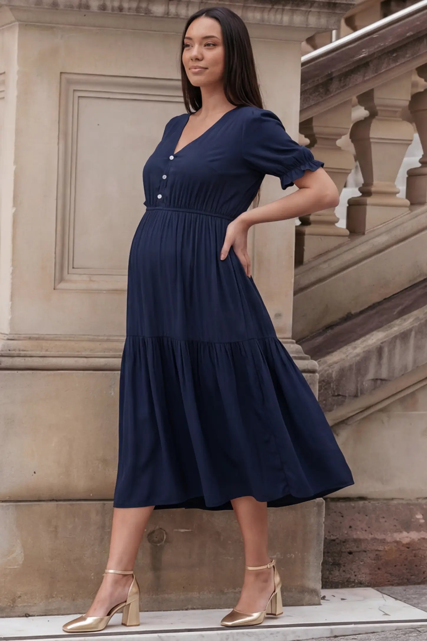 Tiered Hem A-Line Maternity Midi Dress  Tiered Hem A-Line Maternity Midi Dress in navy blue featuring empire waist, elbow-length puff sleeves, V-neckline, and flowy skirt on pregnant model.