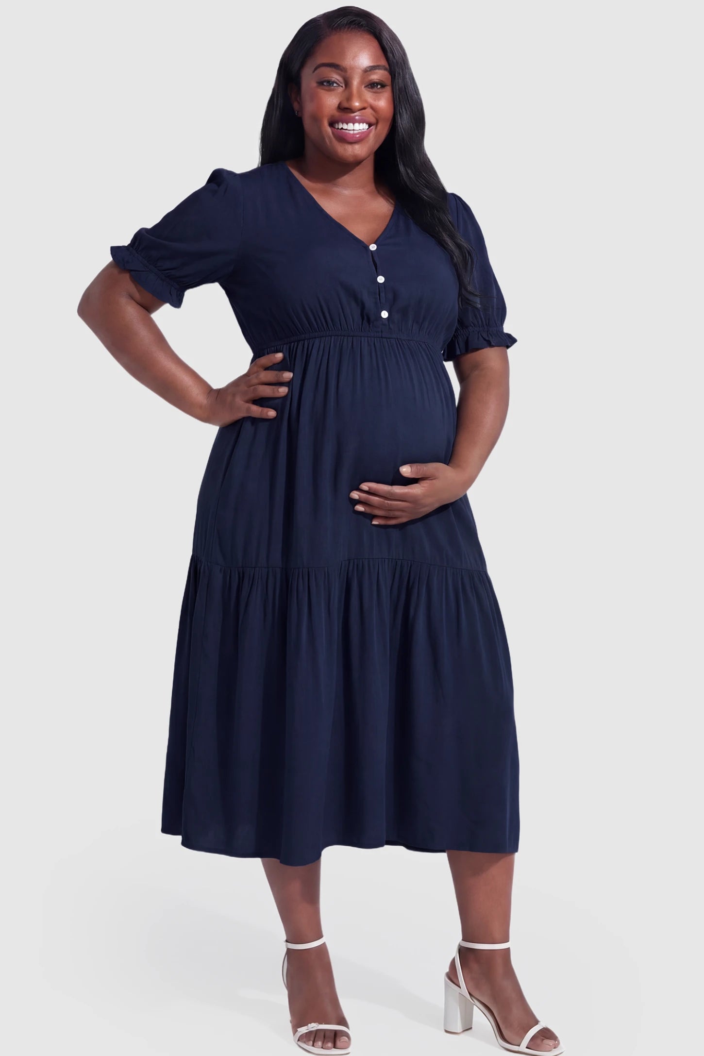 Tiered Hem A-Line Maternity Midi Dress  Tiered Hem A-Line Maternity Midi Dress in navy blue featuring empire waist, elbow-length puff sleeves, V-neckline, and flowy skirt on plus size pregnant model.