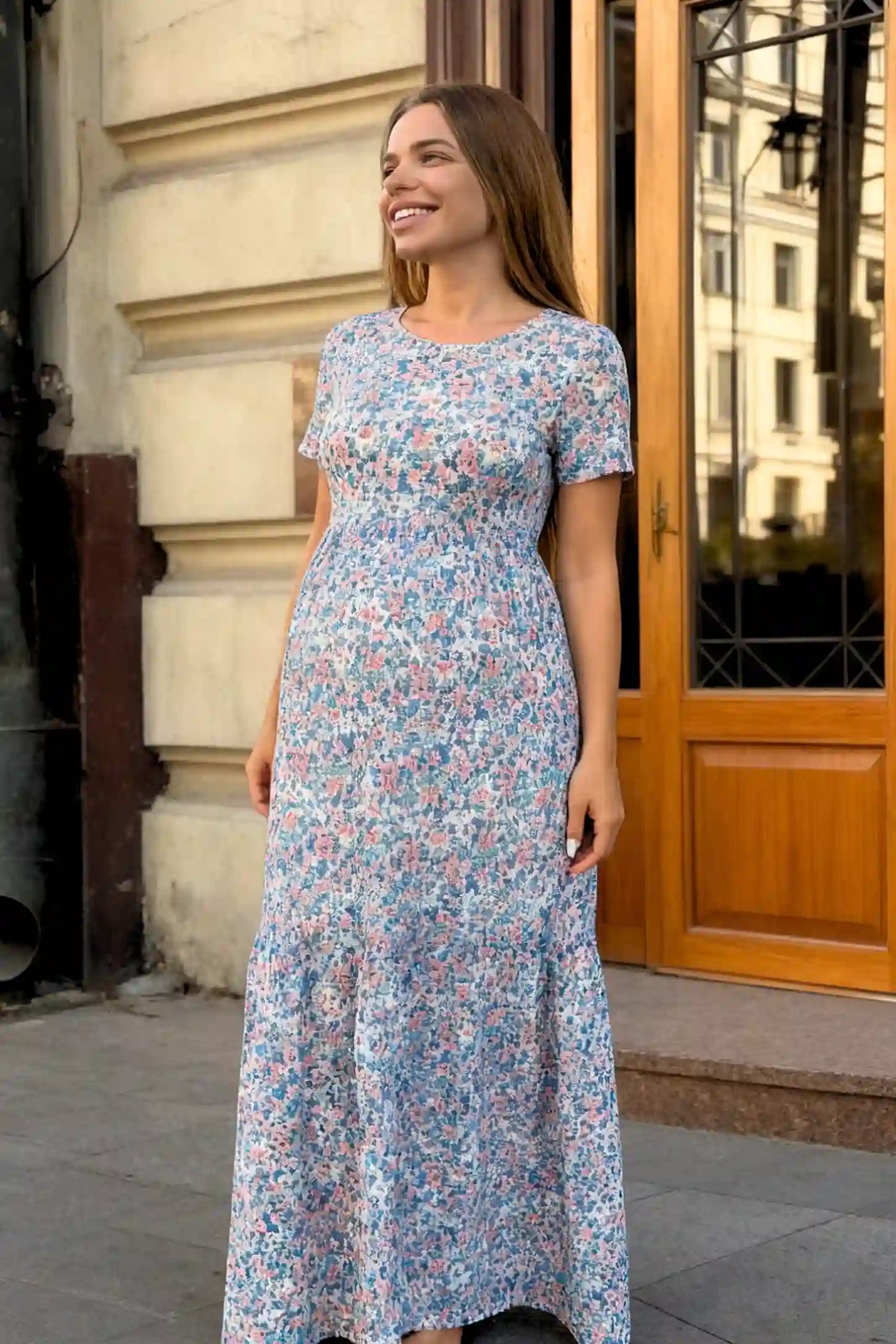 Floral A-Line Maternity Maxi Dress in floral blue print featuring empire waist and tiered hem a pregnant model.