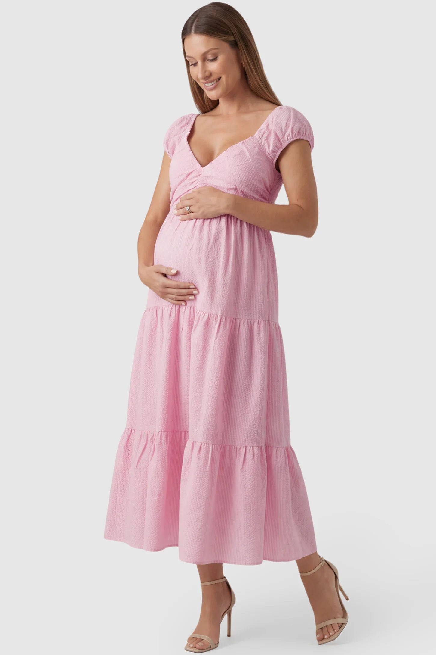 Short Puff Sleeve Tiered Maternity Maxi Dress in pink featuring short sleeves and tiered maternity dress on a pregnant model showing front.