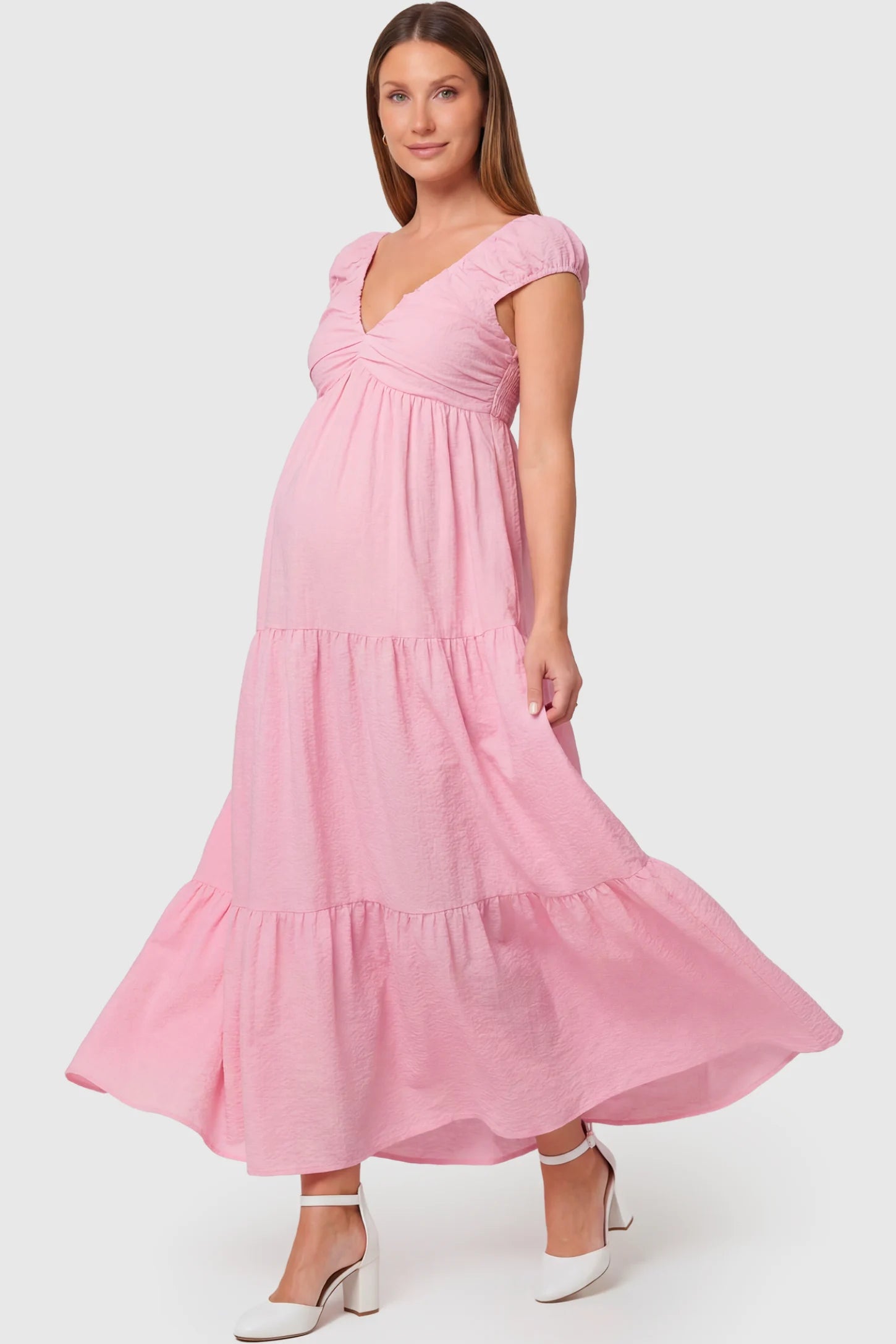 Short Puff Sleeve Tiered Maternity Maxi Dress in pink featuring a sweetheart V-neckline and empire waist on a pregnant model.