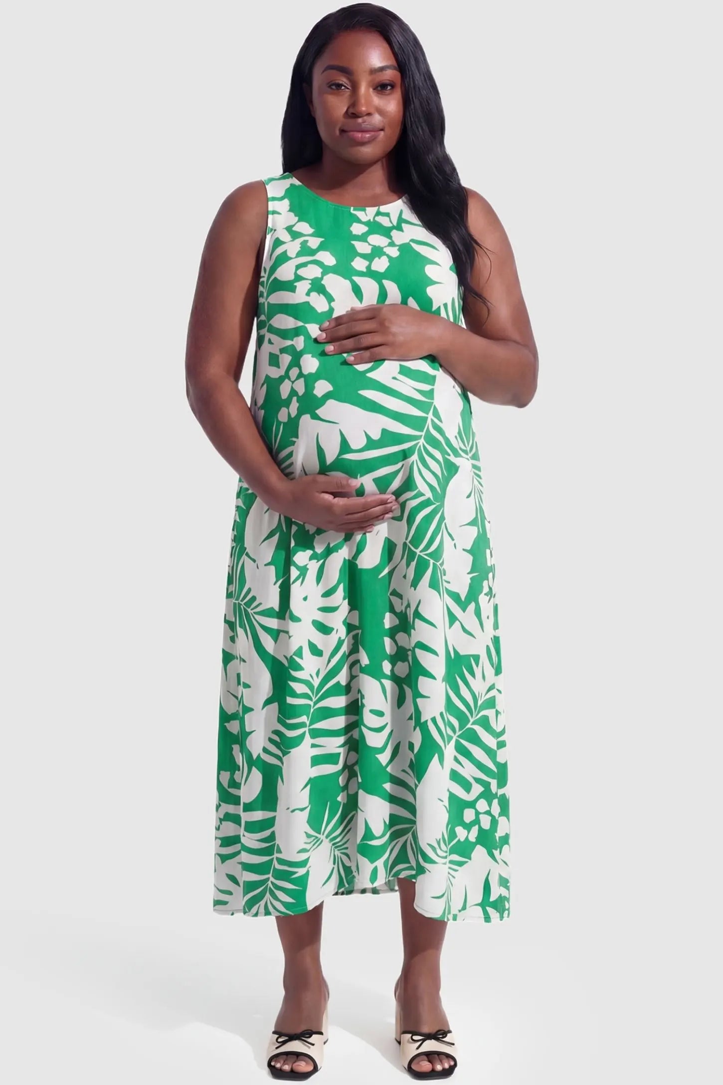 Tropical Print V-Neck Sleeveless Midi Maternity Dress Tropical Print V-Neck Sleeveless Midi Maternity Dress in Green featuring a sleeveless summer design on a pregnant model.