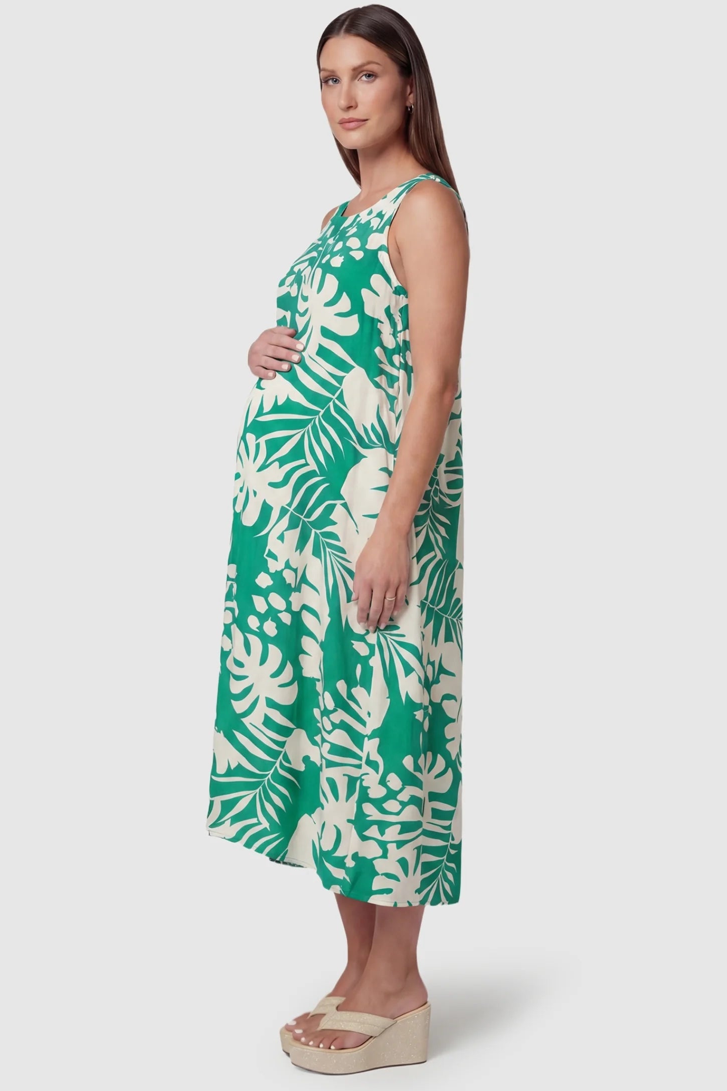 Tropical Print V-Back Sleeveless Midi Maternity Dress Side view of Green Tropical Print V-Back Sleeveless Midi Maternity Dress featuring a midi-length hem on a pregnant model.