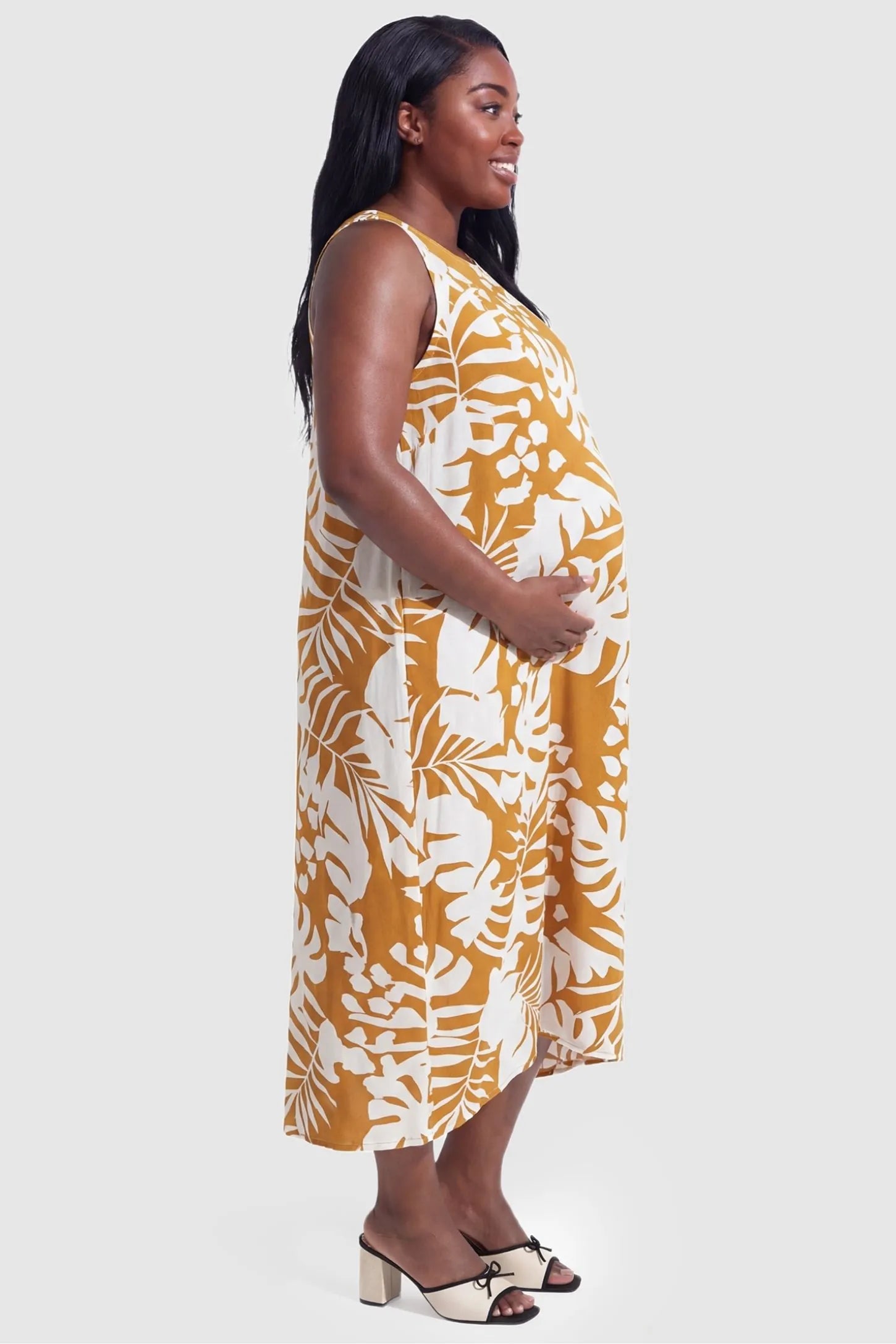 Tropical Print V-Neck Sleeveless Midi Maternity Dress Tropical Print V-Neck Sleeveless Midi Maternity Dress in Orange showing the comfortable mid-calf length on a pregnant model.