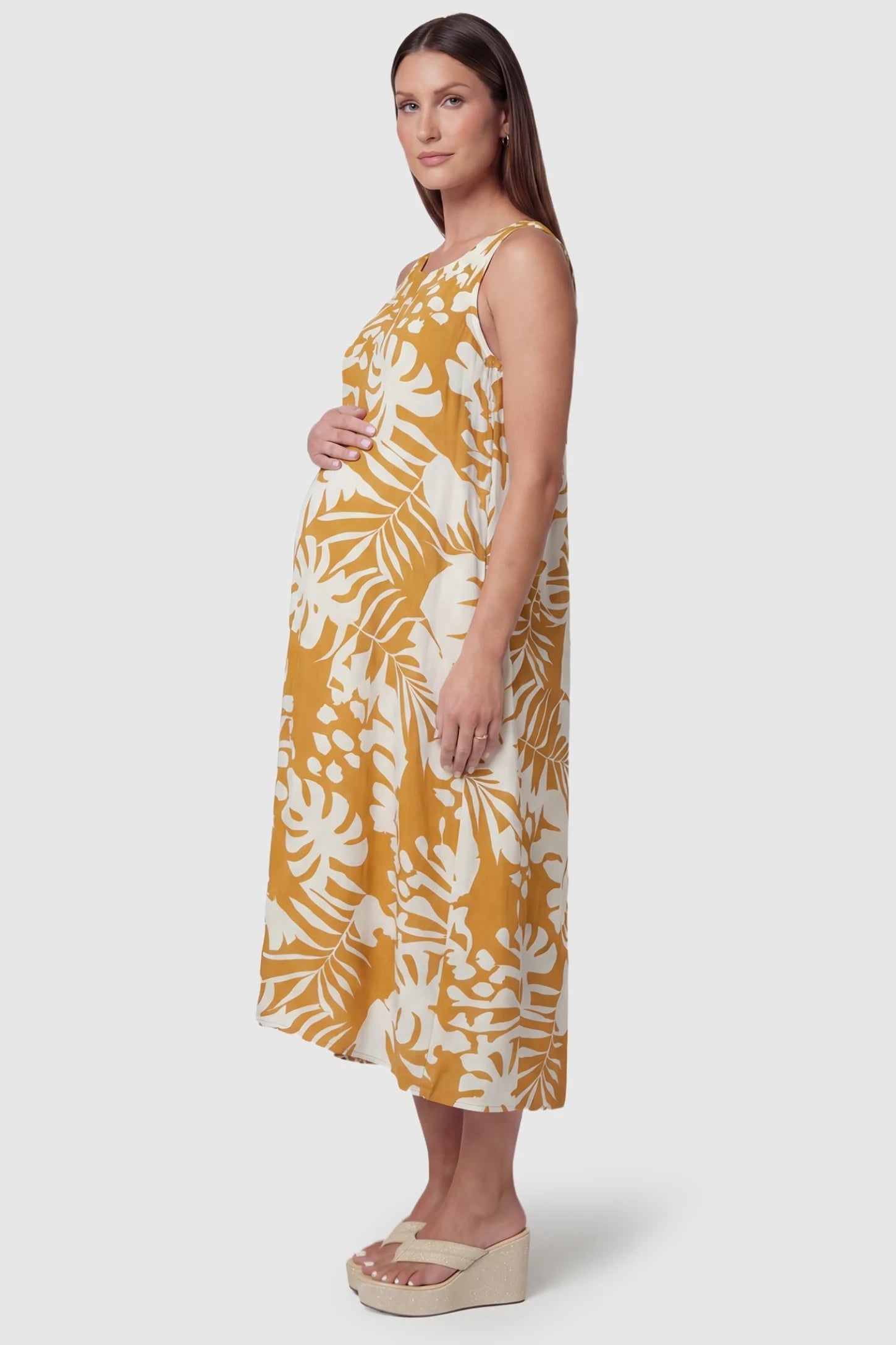 Tropical Print V-Back Sleeveless Midi Maternity Dress Side view of Orange Tropical Print V-Back Sleeveless Midi Maternity Dress featuring a round neckline on a pregnant model.