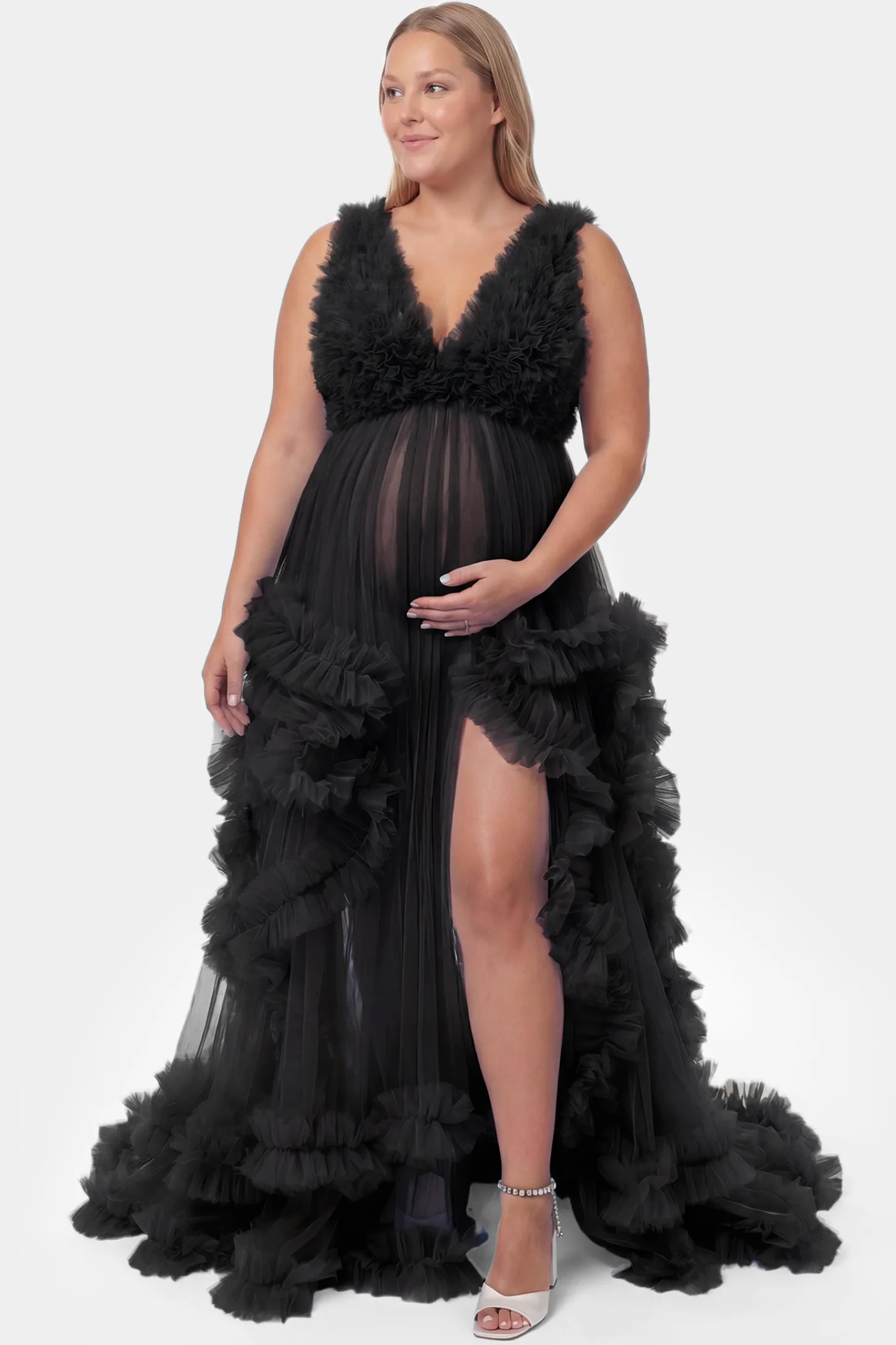 Multi-Layered Tulle Deep V-Neck Sleeveless Maxi Maternity Gown Multi-layered tulle deep V-neck sleeveless maxi maternity gown in black featuring flowing pleated silhouette in full body front view on a plus-size model
