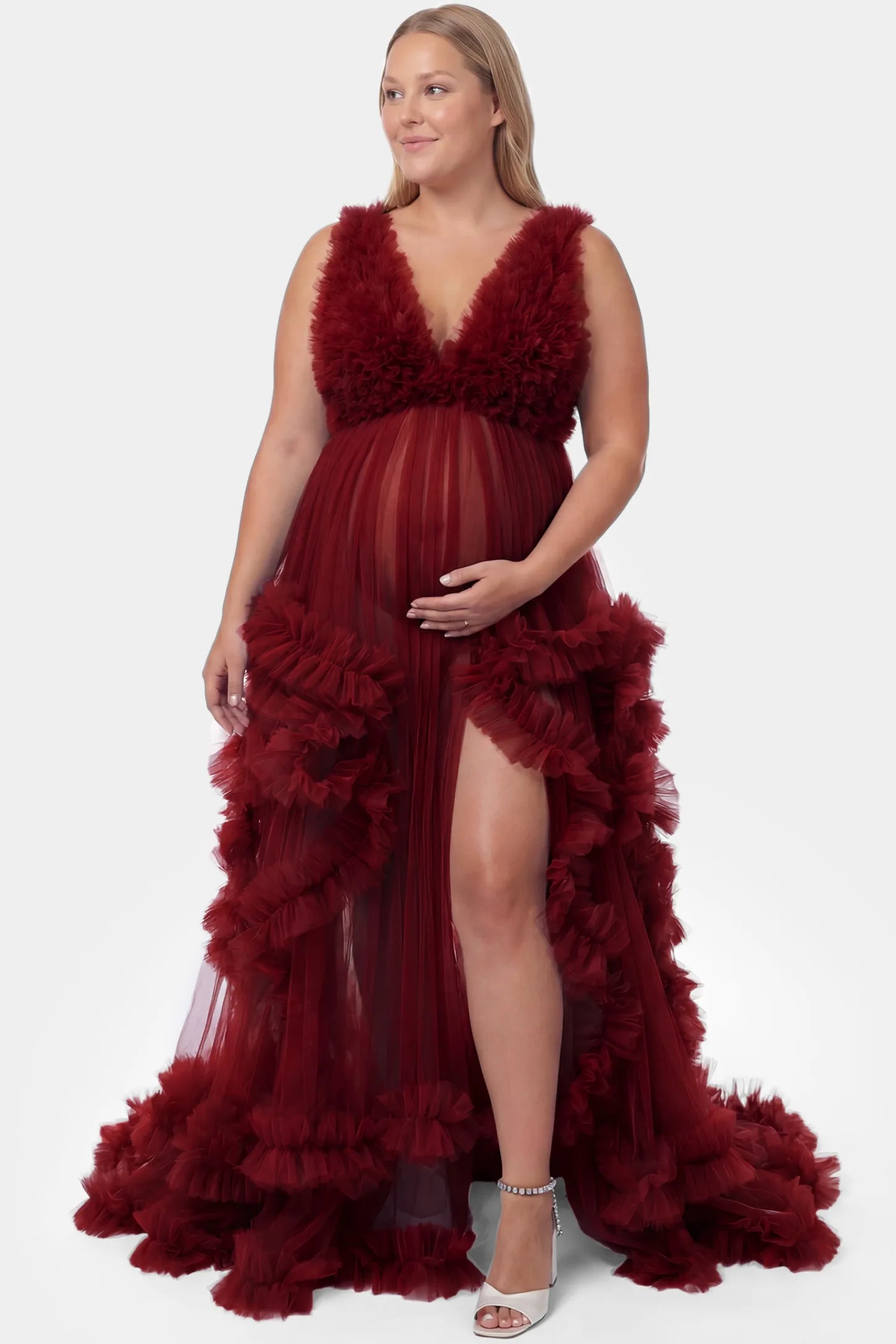 Multi-Layered Tulle Deep V-Neck Sleeveless Maxi Maternity Gown Multi-layered tulle deep V-neck sleeveless maxi maternity gown in burgundy featuring flowing pleated silhouette in full body front view on a plus-size model