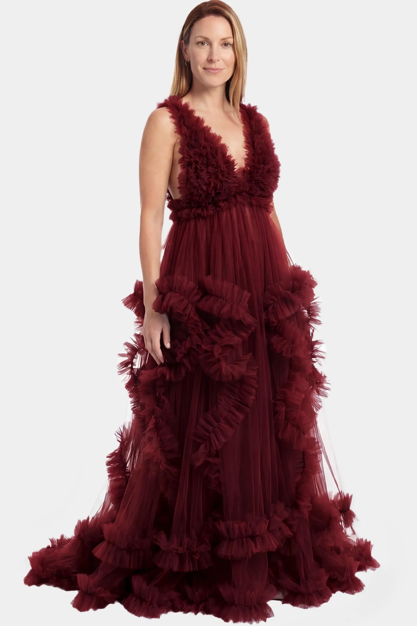 Multi-Layered Tulle Deep V-Neck Sleeveless Maxi Maternity Gown Multi-layered tulle deep V-neck sleeveless maxi maternity gown in burgundy featuring flowing pleated silhouette in full body front view on a postpartum model