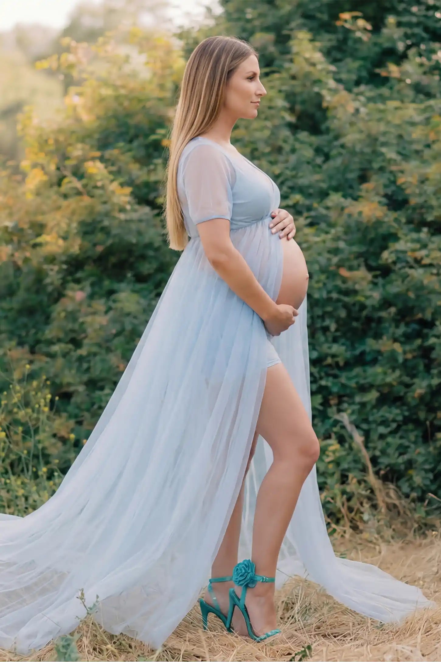 Tulle-Lace Sheer Half Sleeve Maternity Photoshoot Gown Tulle-lace sheer half sleeve maternity gown in light blue with delicate lace-spliced detail and high front slit, side view on pregnant model