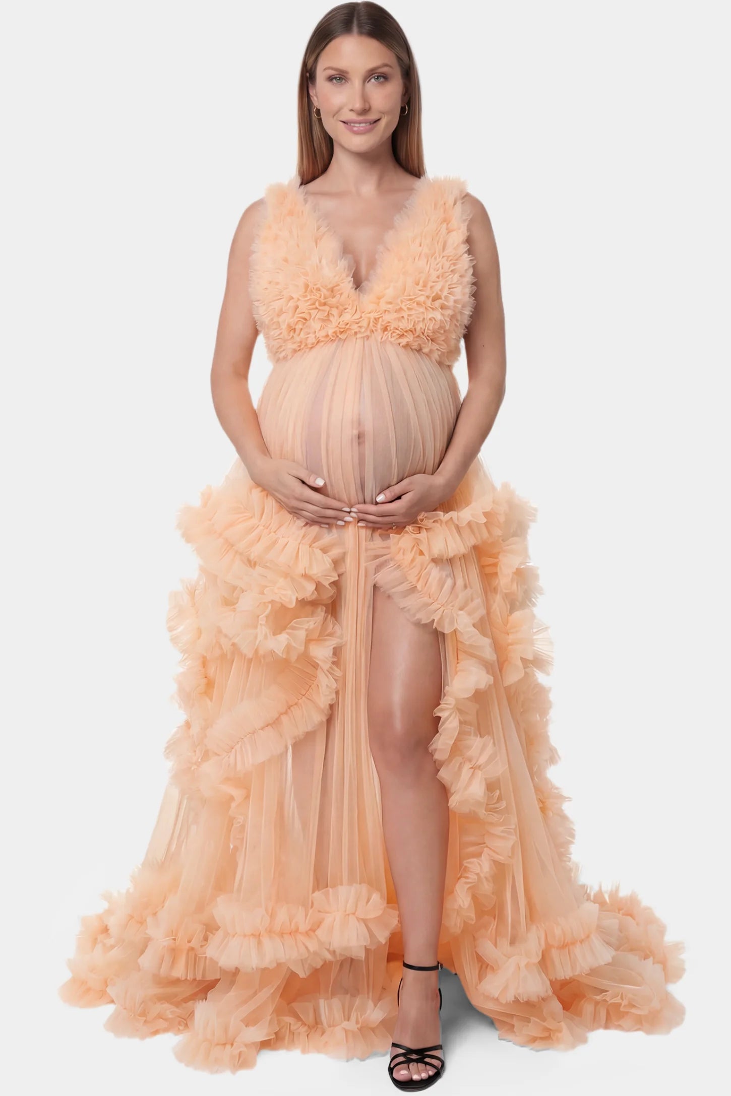 Multi-Layered Tulle Deep V-Neck Sleeveless Maxi Maternity Gown Multi-layered tulle deep V-neck sleeveless maxi maternity gown in mustard yellow featuring flowing pleated silhouette in full body front view on a pregnant model