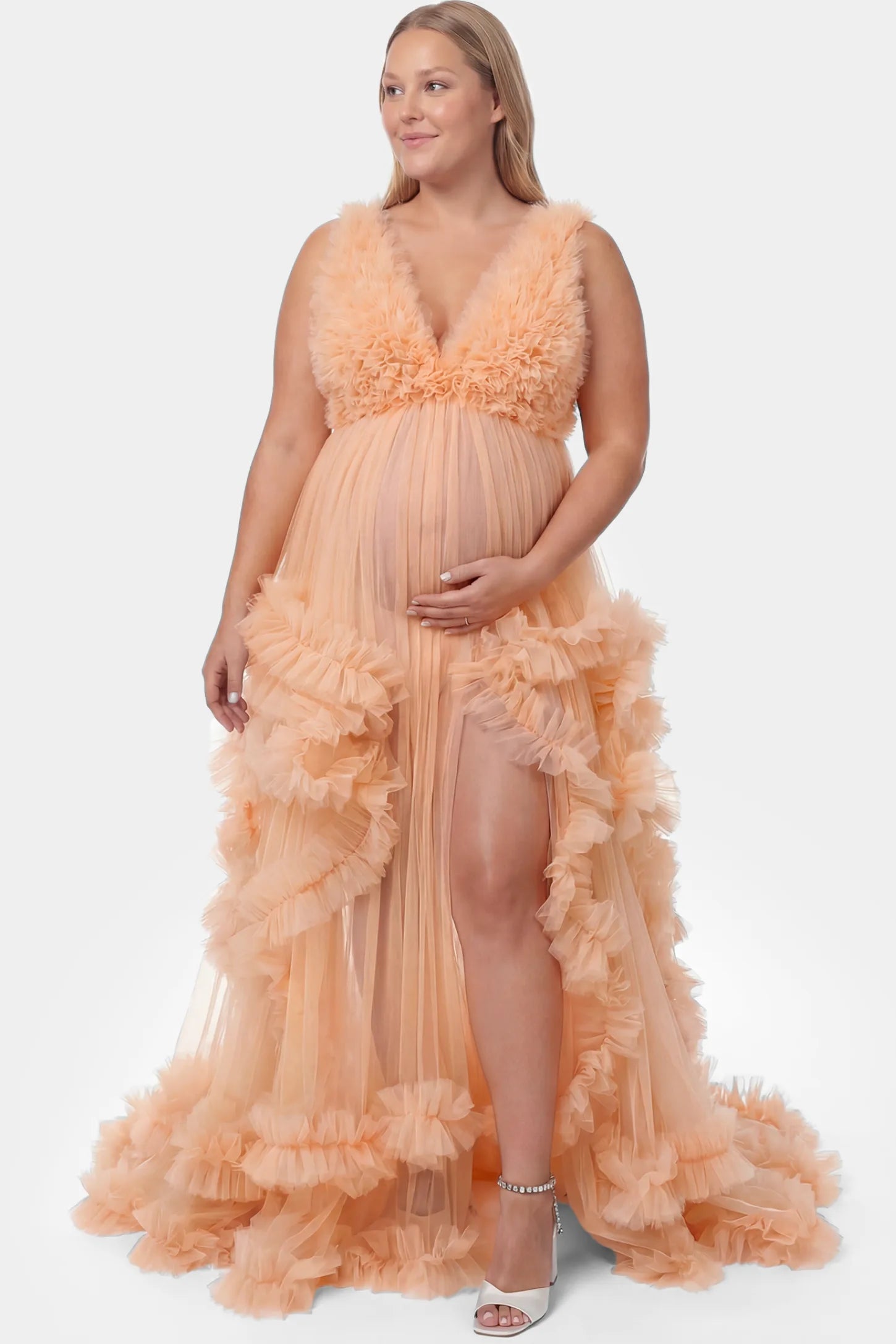 Multi-Layered Tulle Deep V-Neck Sleeveless Maxi Maternity Gown Multi-layered tulle deep V-neck sleeveless maxi maternity gown in mustard yellow featuring flowing pleated silhouette in full body front view on a plus-size model