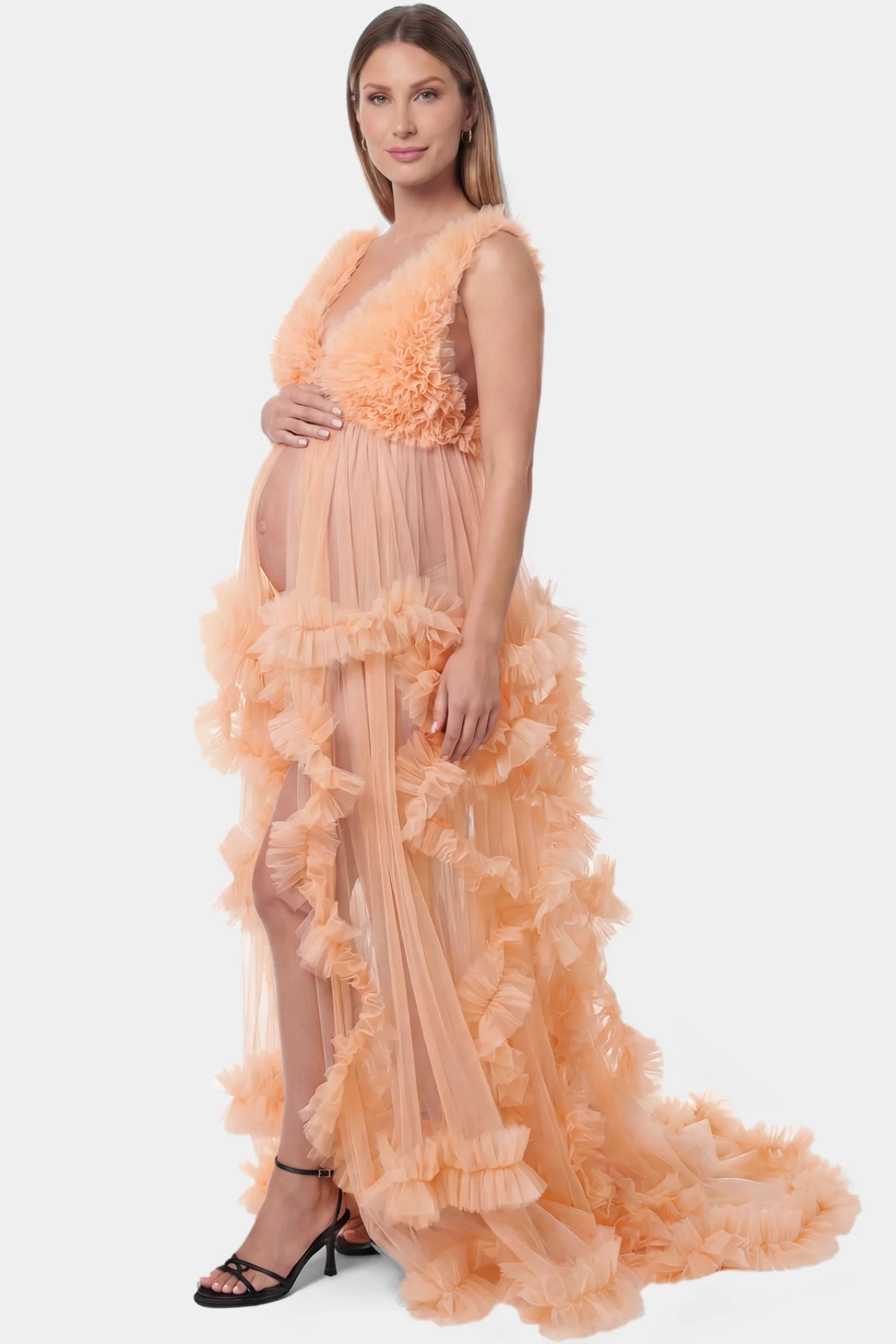 Multi-Layered Tulle Deep V-Neck Sleeveless Maxi Maternity Gown Multi-layered tulle deep V-neck sleeveless maxi maternity gown in mustard yellow featuring flowing pleated silhouette in full body side view on a pregnant model