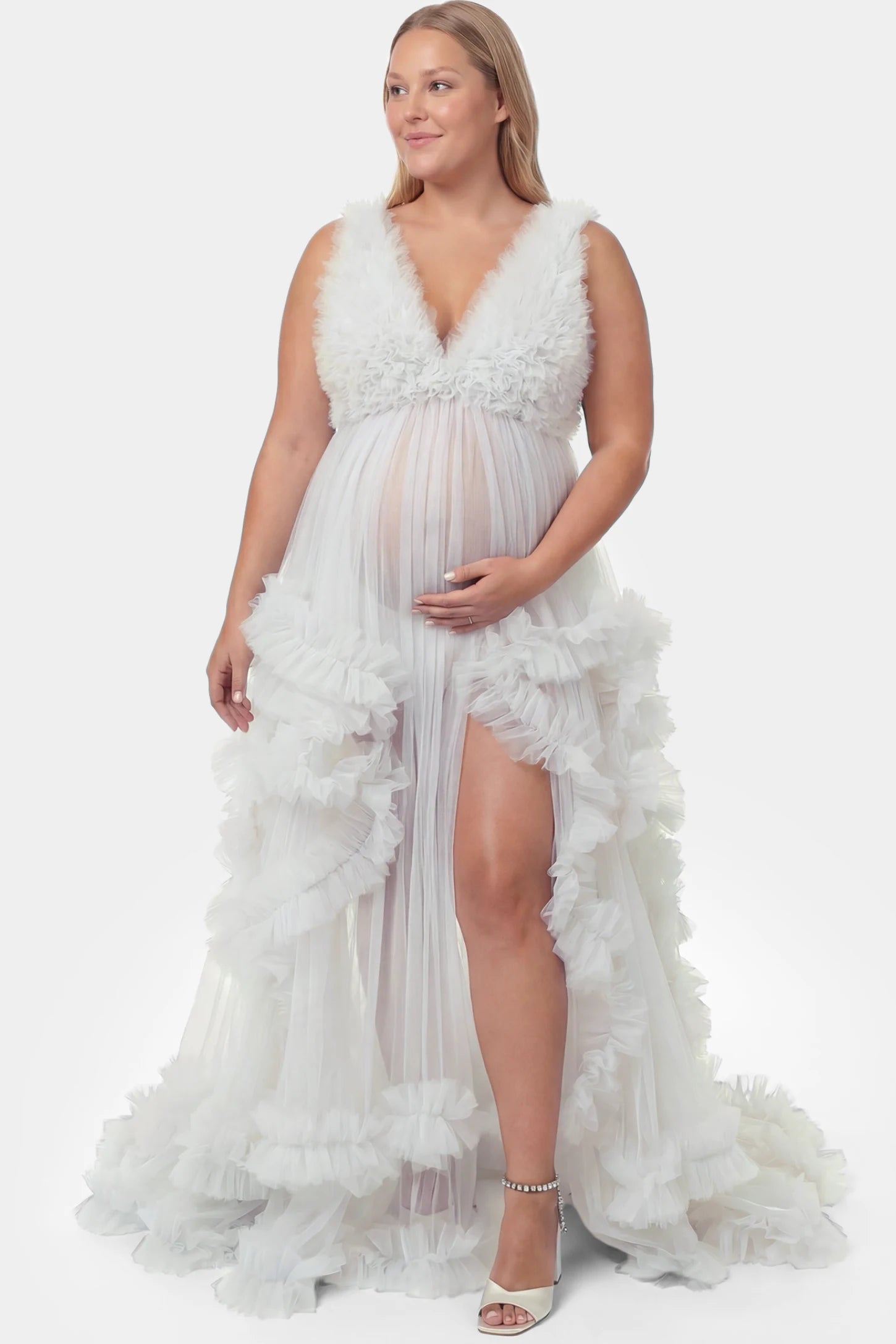 Multi-Layered Tulle Deep V-Neck Sleeveless Maxi Maternity Gown Multi-layered tulle deep V-neck sleeveless maxi maternity gown in white featuring flowing pleated silhouette in full body front view on a plus-size model