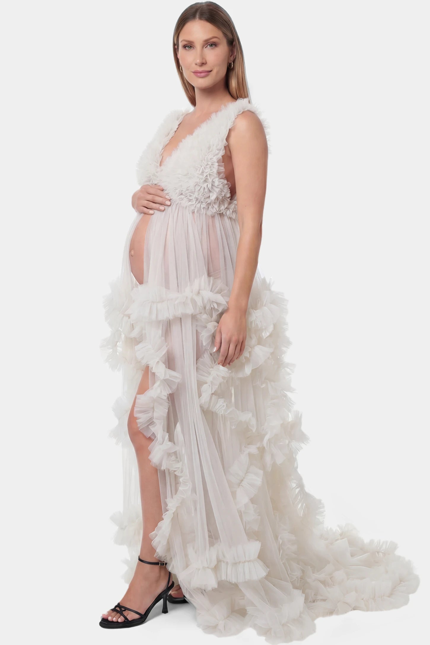 Multi-Layered Tulle Deep V-Neck Sleeveless Maxi Maternity Gown Multi-layered tulle deep V-neck sleeveless maxi maternity gown in white featuring flowing pleated silhouette in full body side view on a pregnant model