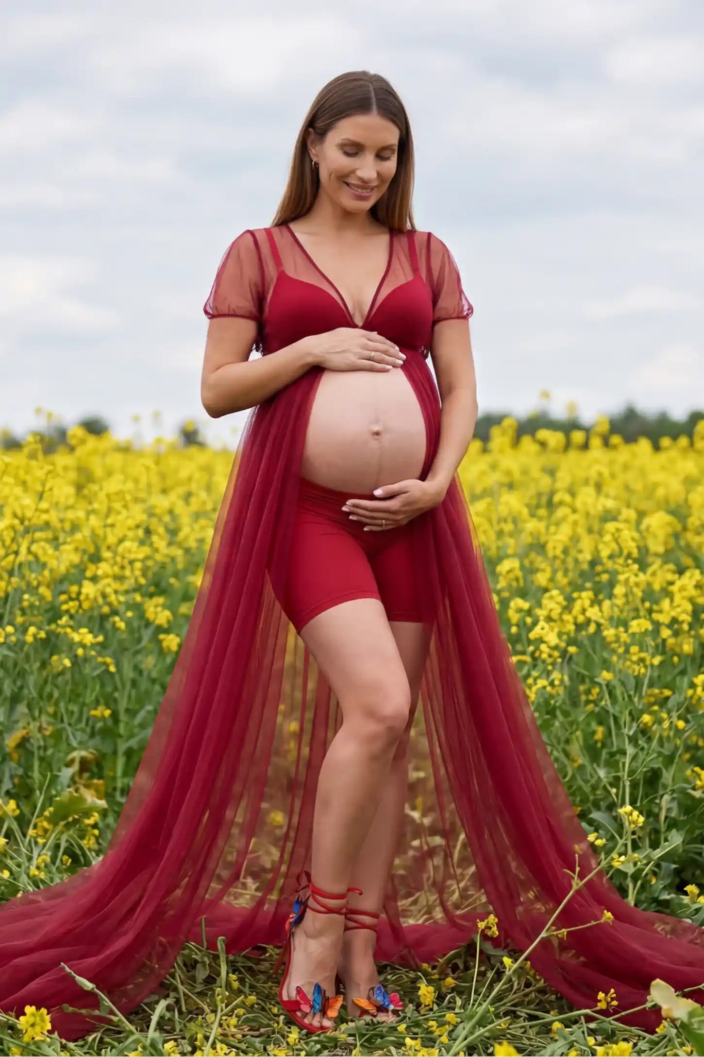 Tulle-lace sheer half sleeve maternity gown in wine red with delicate lace-spliced detail and high front slit, front view on pregnant model