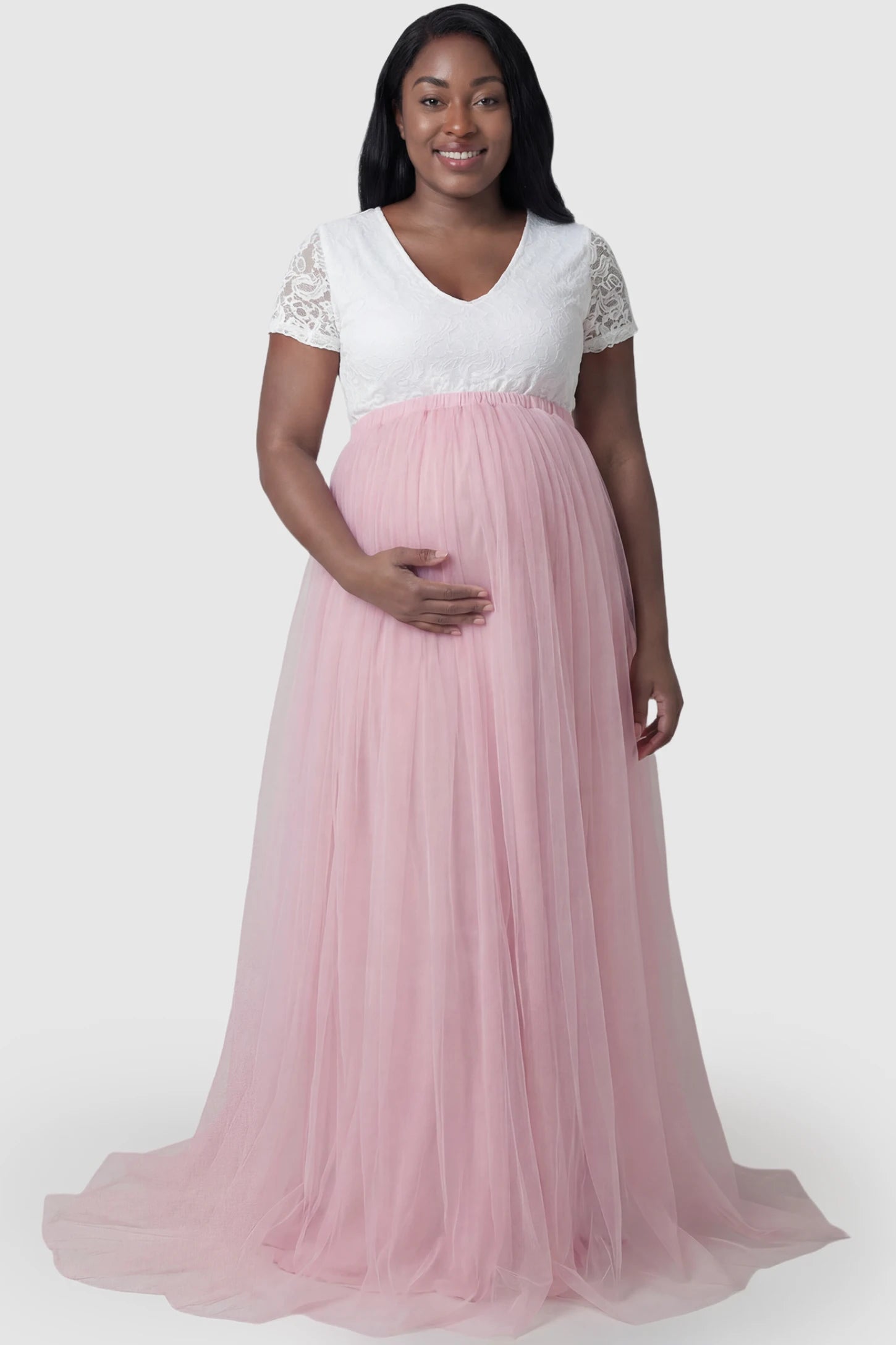 Lace & Tulle Short Sleeve Maternity Gown Lace & Tulle Short Sleeve Maternity Gown in pink featuring V-neck lace bodice, empire waist, and flowing tulle train on plus size pregnant model.