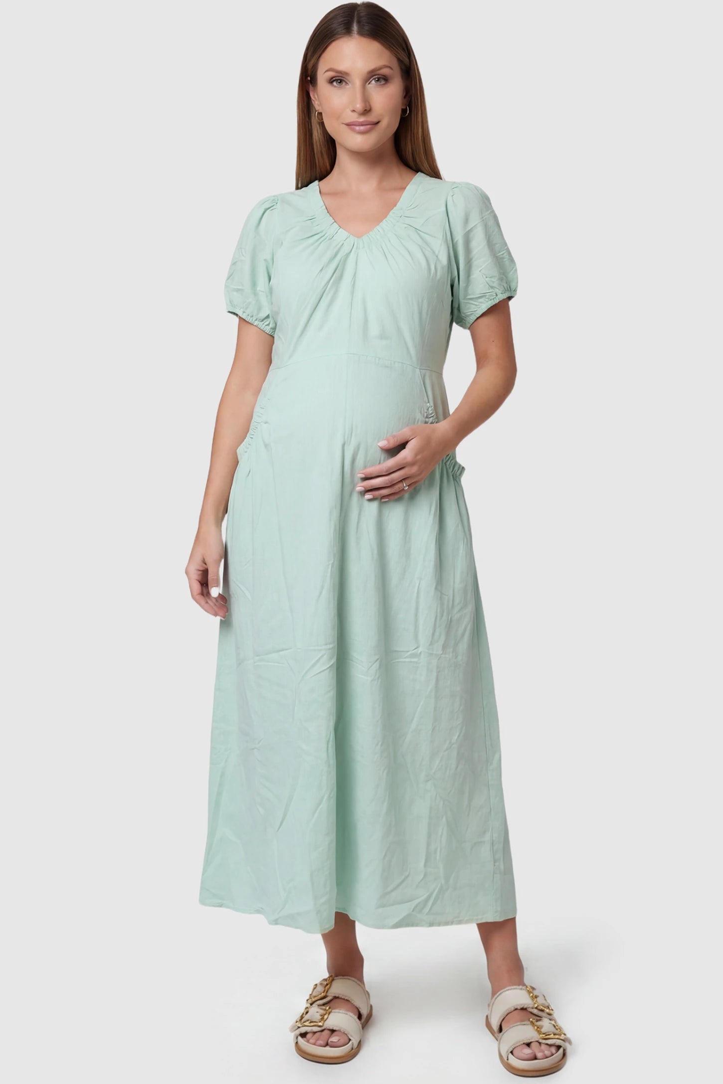 V-Neck Short Sleeve Maternity Midi Dress with Pockets V-neck short sleeve maternity midi dress with pockets in green with V-neckline detail, front view on pregnant model