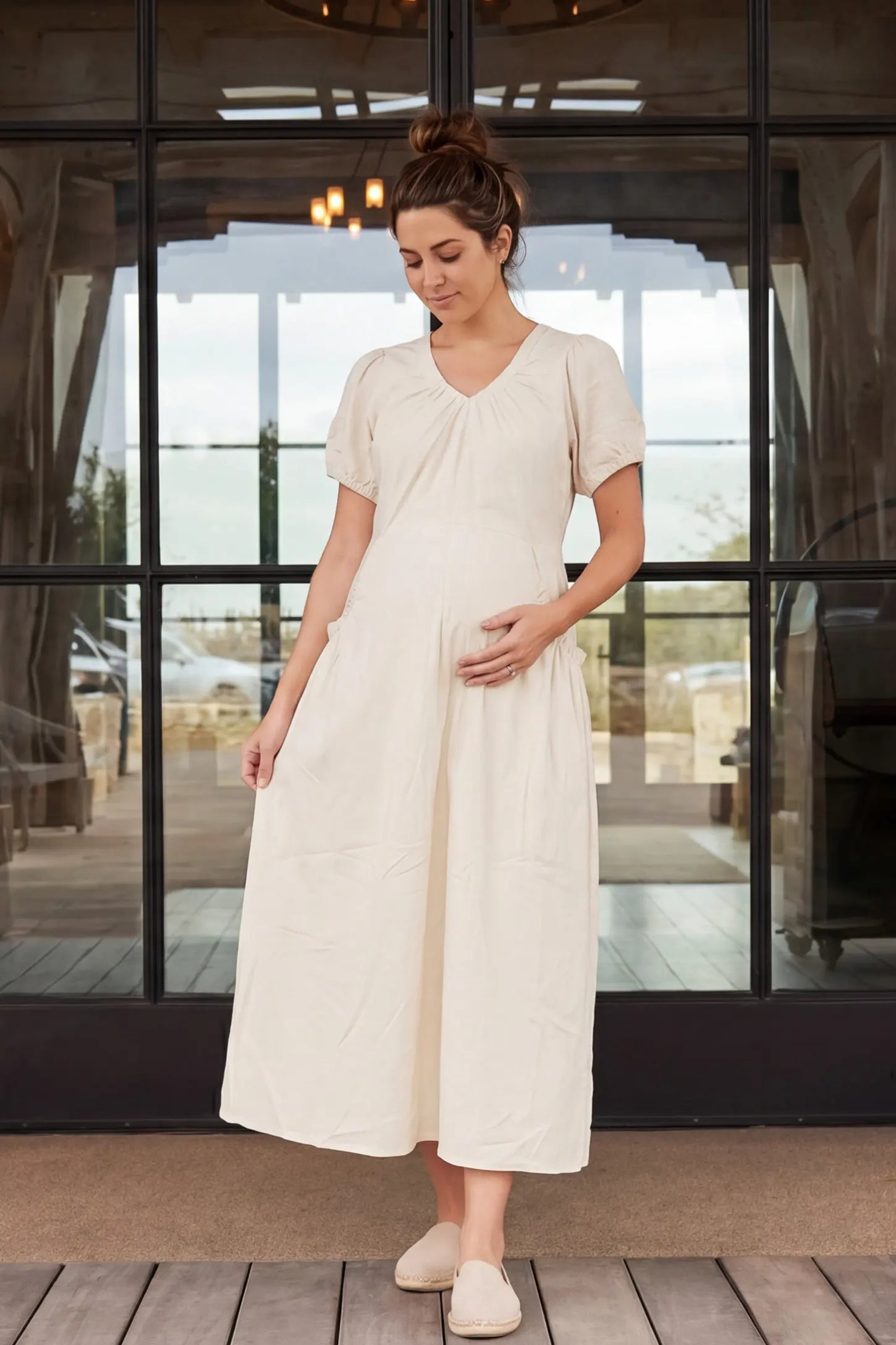 V-Neck Short Sleeve Maternity Midi Dress with Pockets V-neck short sleeve maternity midi dress with pockets in white with V-neckline detail, front view on pregnant model