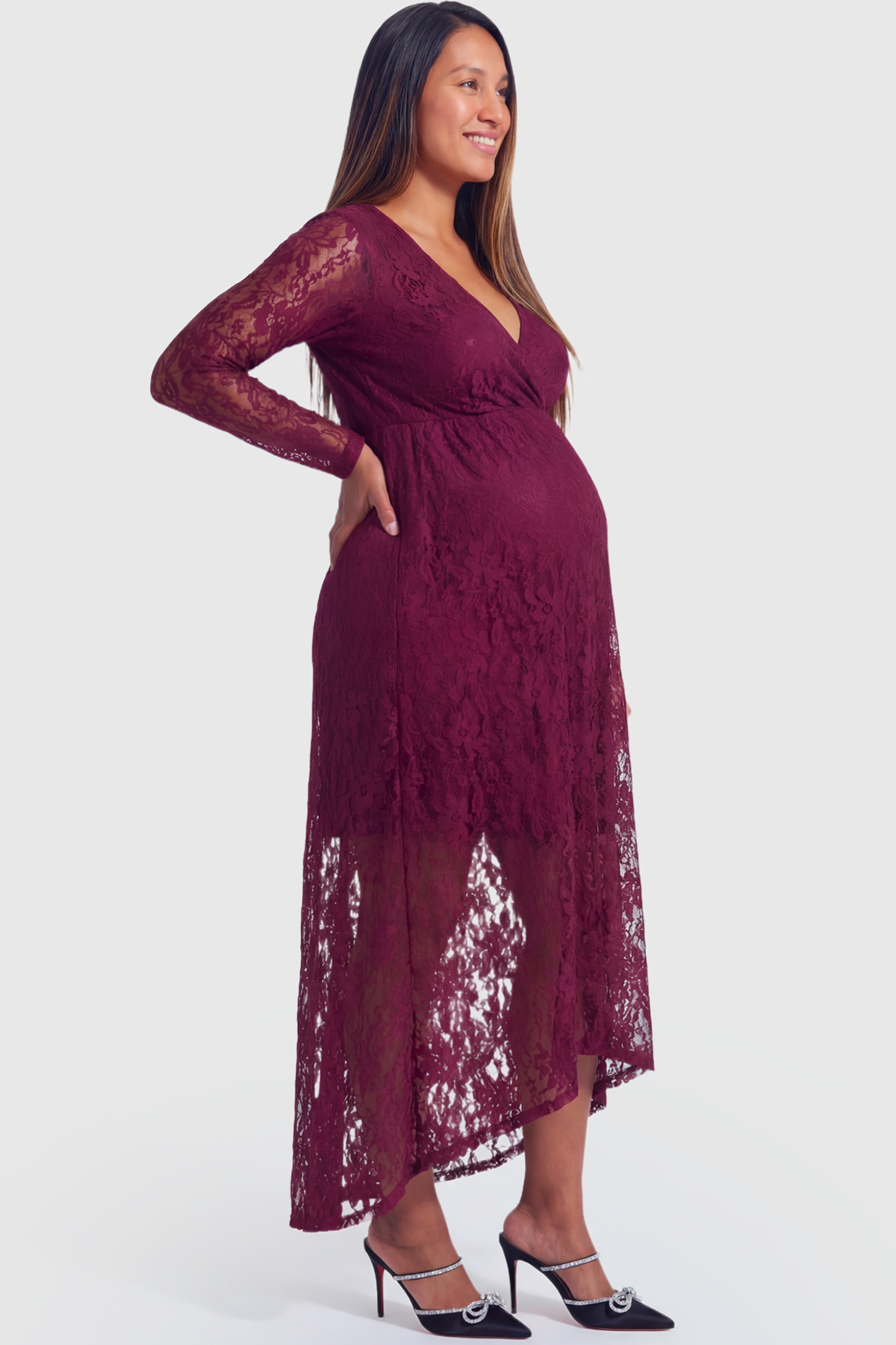 Hi-Low Hem Wrap Neck Maternity Midi Dress in wine red lace featuring long sleeves and empire waist on a pregnant model.