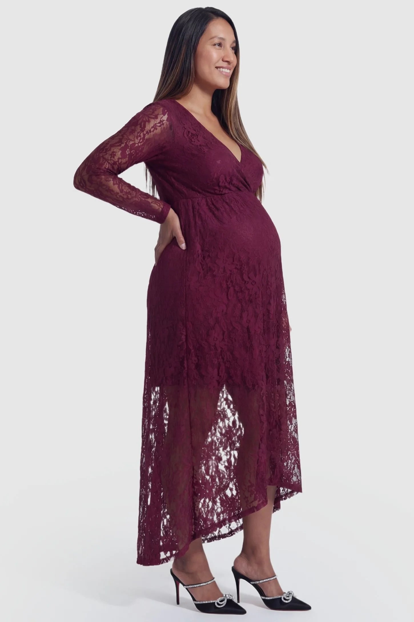 Hi-Low Hem Wrap Neck Maternity Midi Dress Hi-Low Hem Wrap Neck Maternity Midi Dress in wine red lace featuring long sleeves and empire waist on a pregnant model, side view