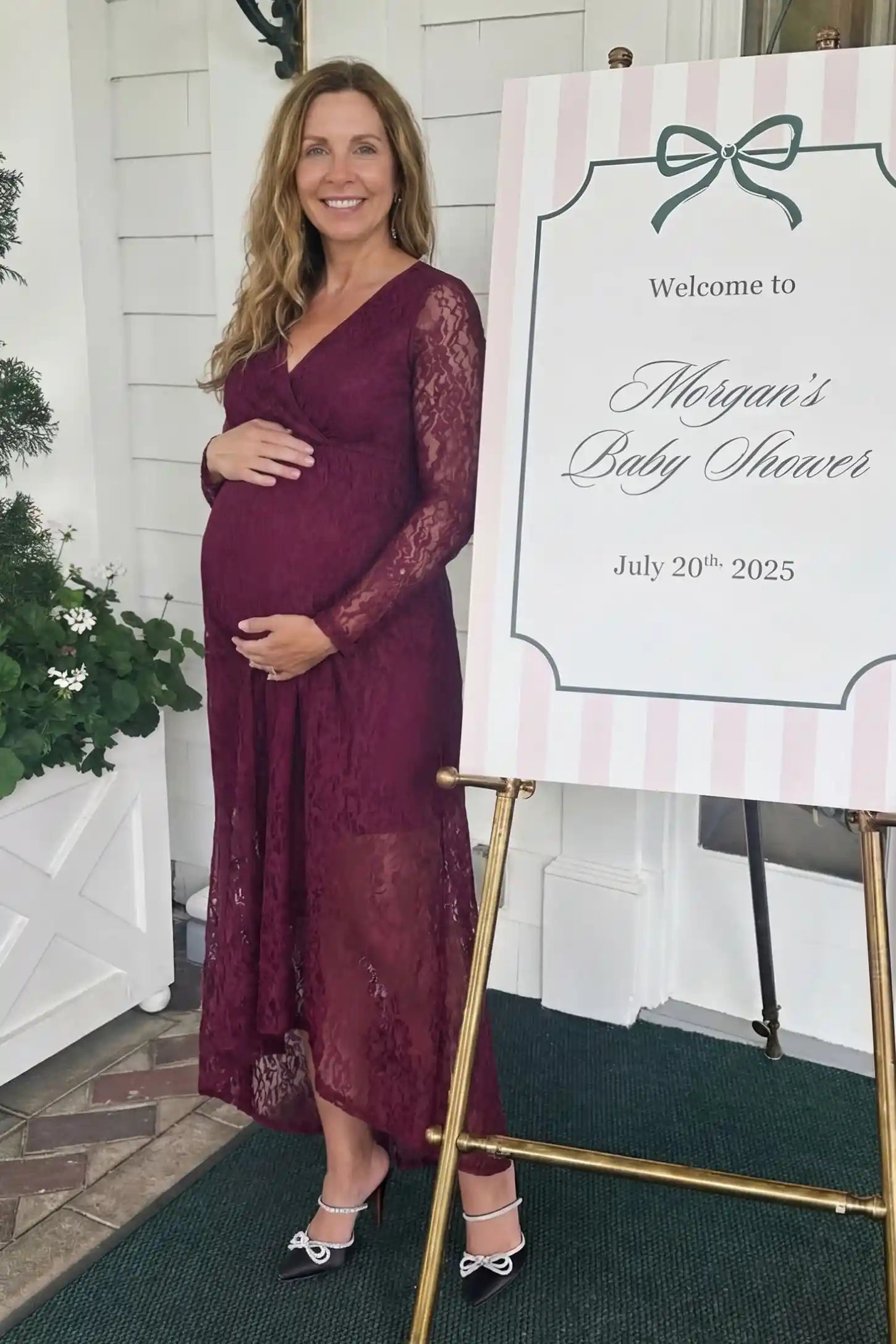 Hi-Low Hem Wrap Neck Maternity Midi Dress in wine red lace featuring long sleeves and empire waist on a pregnant model, front view