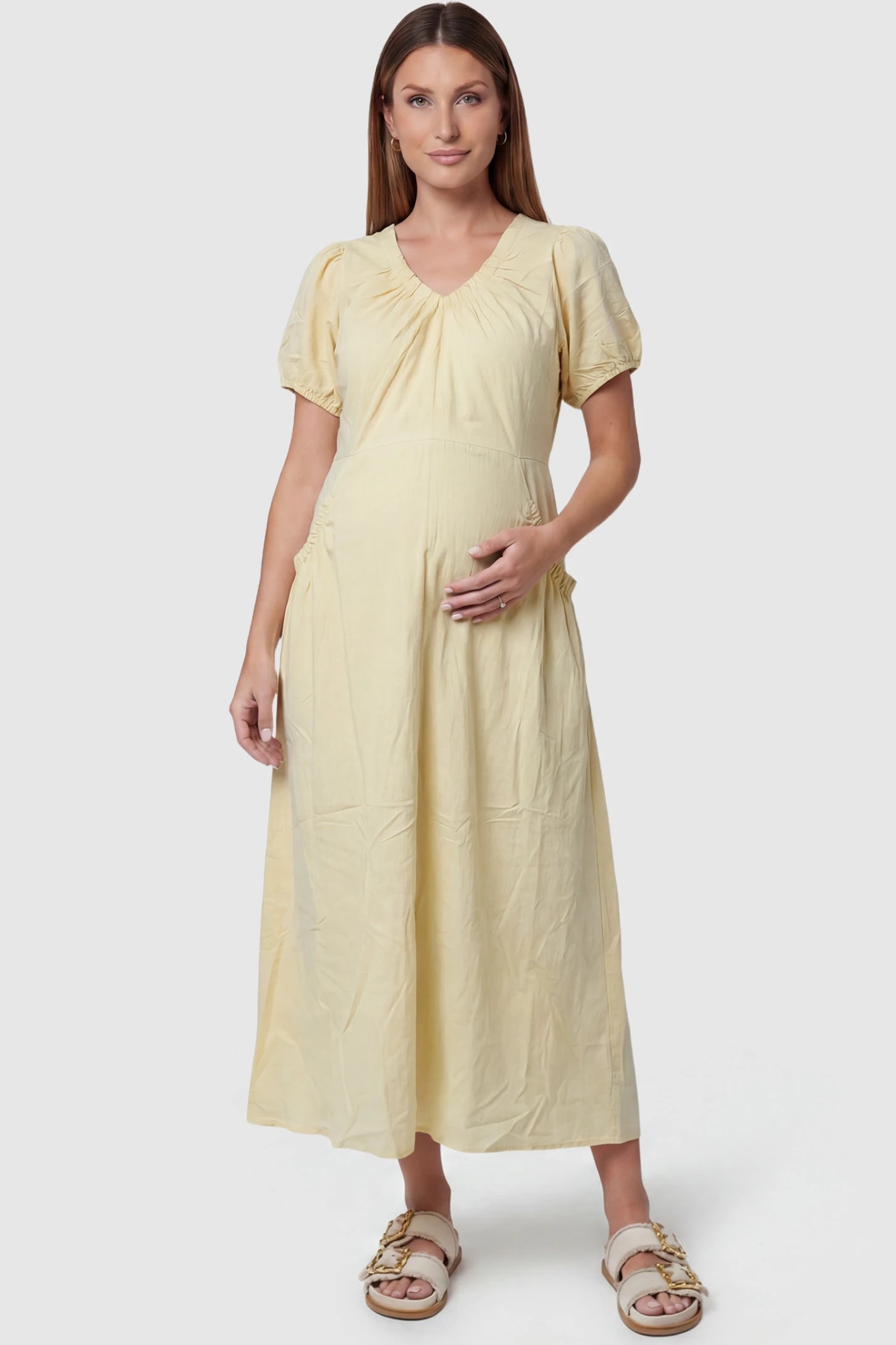 V-Neck Short Sleeve Maternity Midi Dress with Pockets V-neck short sleeve maternity midi dress with pockets in yellow with V-neckline detail, front view on pregnant model
