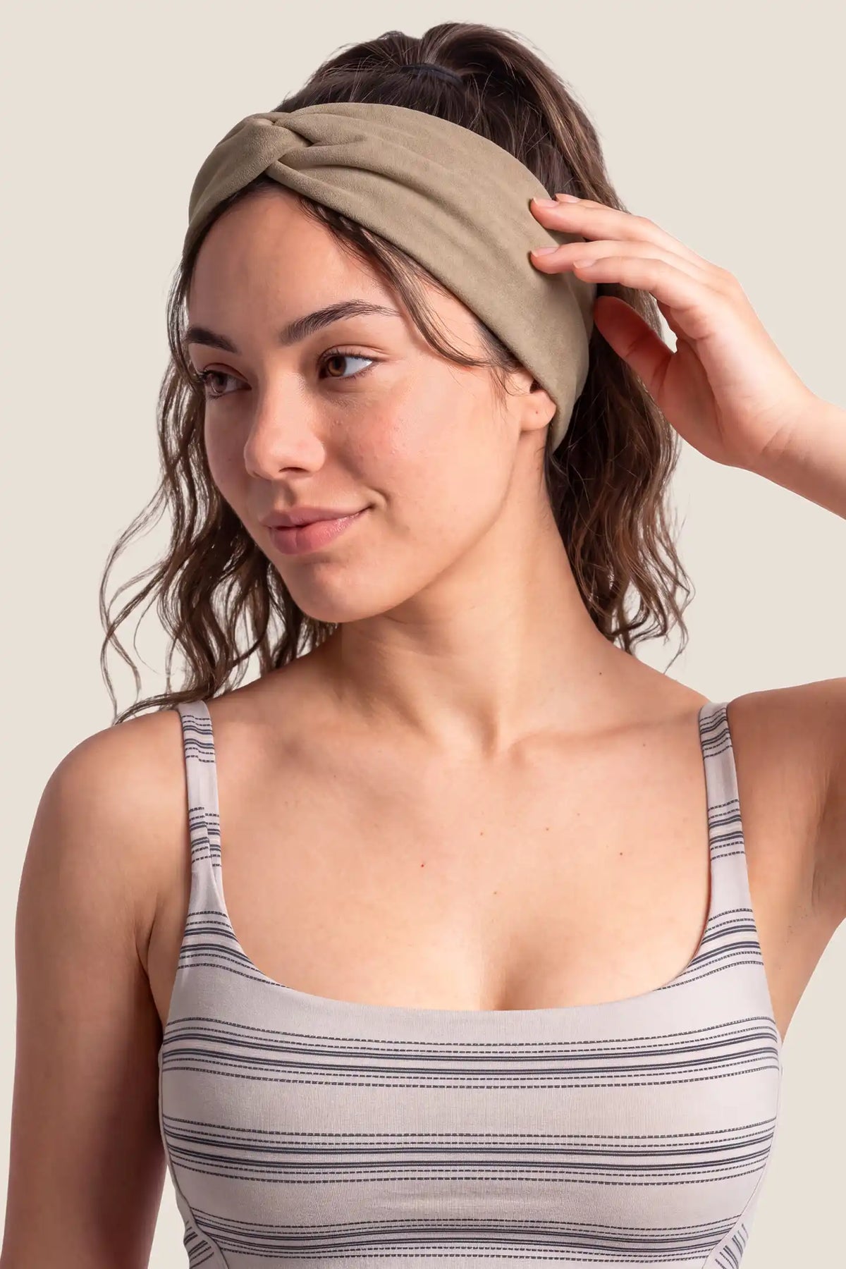 Wide Crossed Headband Wide Crossed Headband in Oatmeal Khaki featuring a Korean-inspired front crossover twist design and comfortable wide band profile on a model, close-up portrait view.