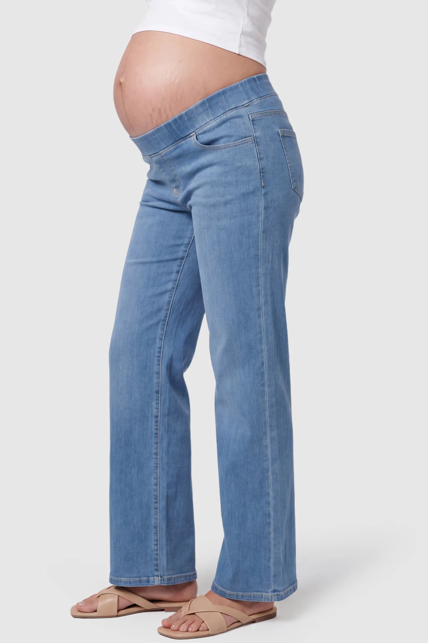High-Rise Wide Leg Maternity Jeans High-Rise Wide Leg Maternity Jeans in light blue featuring over-the-belly support and wide-leg silhouette on a pregnant model, side view.