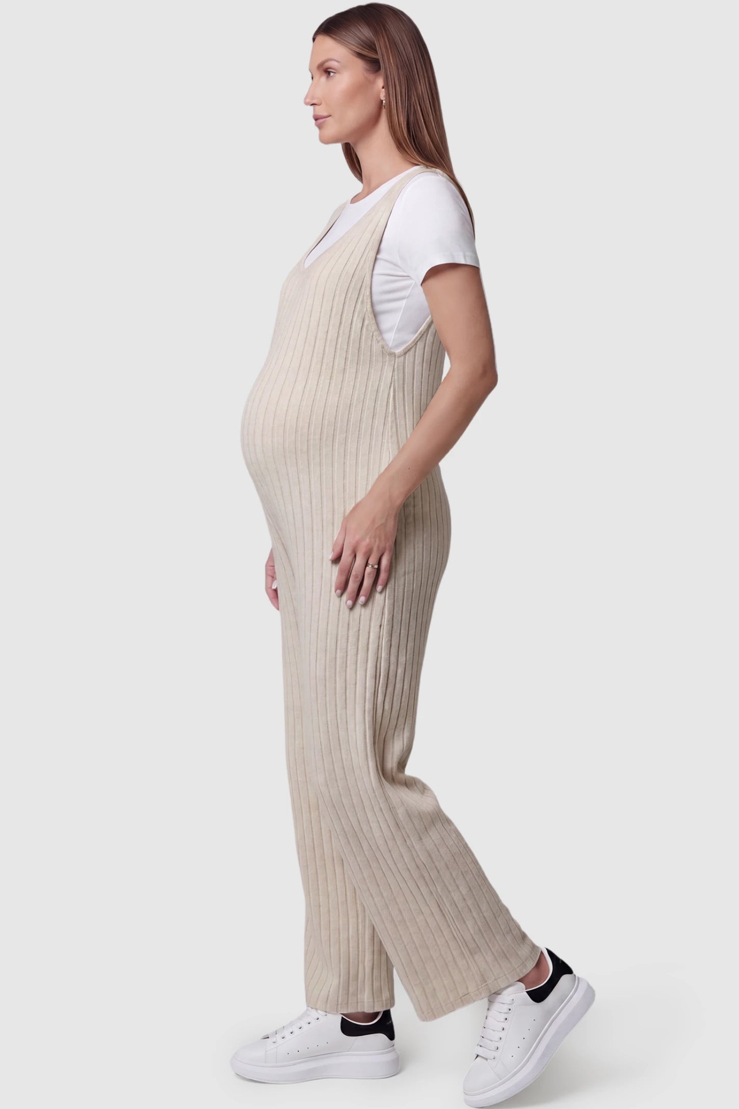 Ribbed Sleeveless Wide-Leg Maternity Jumpsuit Ribbed sleeveless wide-leg maternity jumpsuit in apricot with sleeveless ribbed design, side view on pregnant model