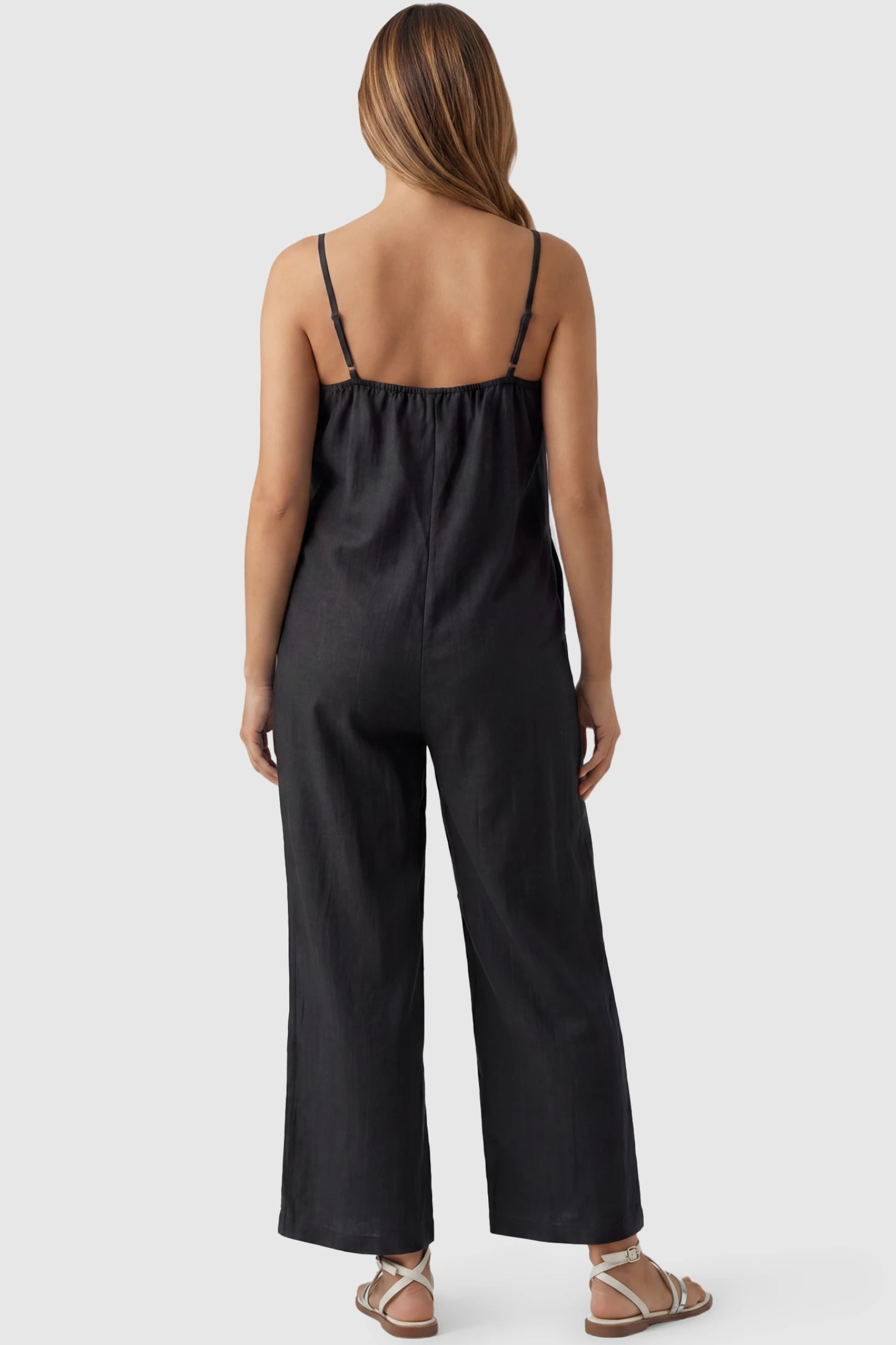 Wide‑Leg Scoop Neck Pocketed Maternity Jumpsuit Wide-leg scoop neck pocketed maternity jumpsuit in black with sleeveless design, thin strap, and wide-leg silhouette, back view on pregnant model