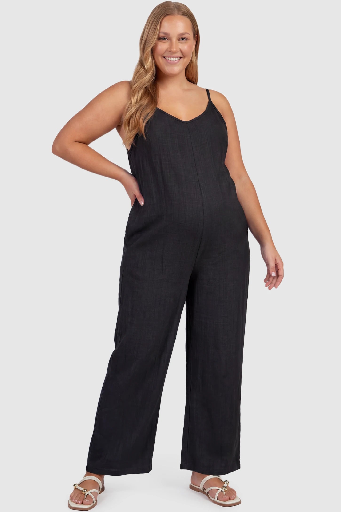 Wide‑Leg Scoop Neck Pocketed Maternity Jumpsuit Wide-leg scoop neck pocketed maternity jumpsuit in black with sleeveless design, thin strap, and wide-leg silhouette, front view on plus-size model