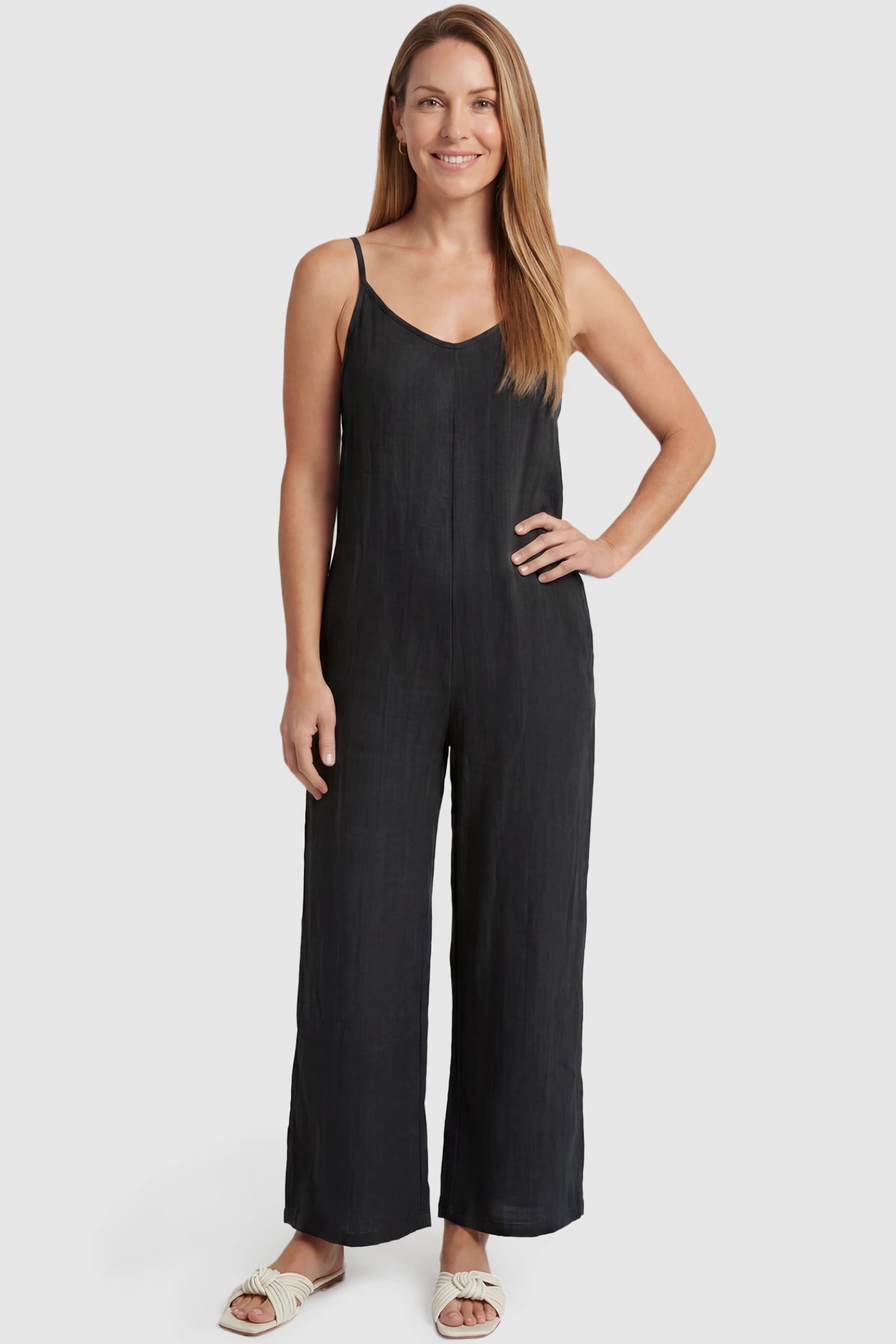 Wide‑Leg Scoop Neck Pocketed Maternity Jumpsuit Wide-leg scoop neck pocketed maternity jumpsuit in black with sleeveless design, thin strap, and wide-leg silhouette, front view on postpartum model