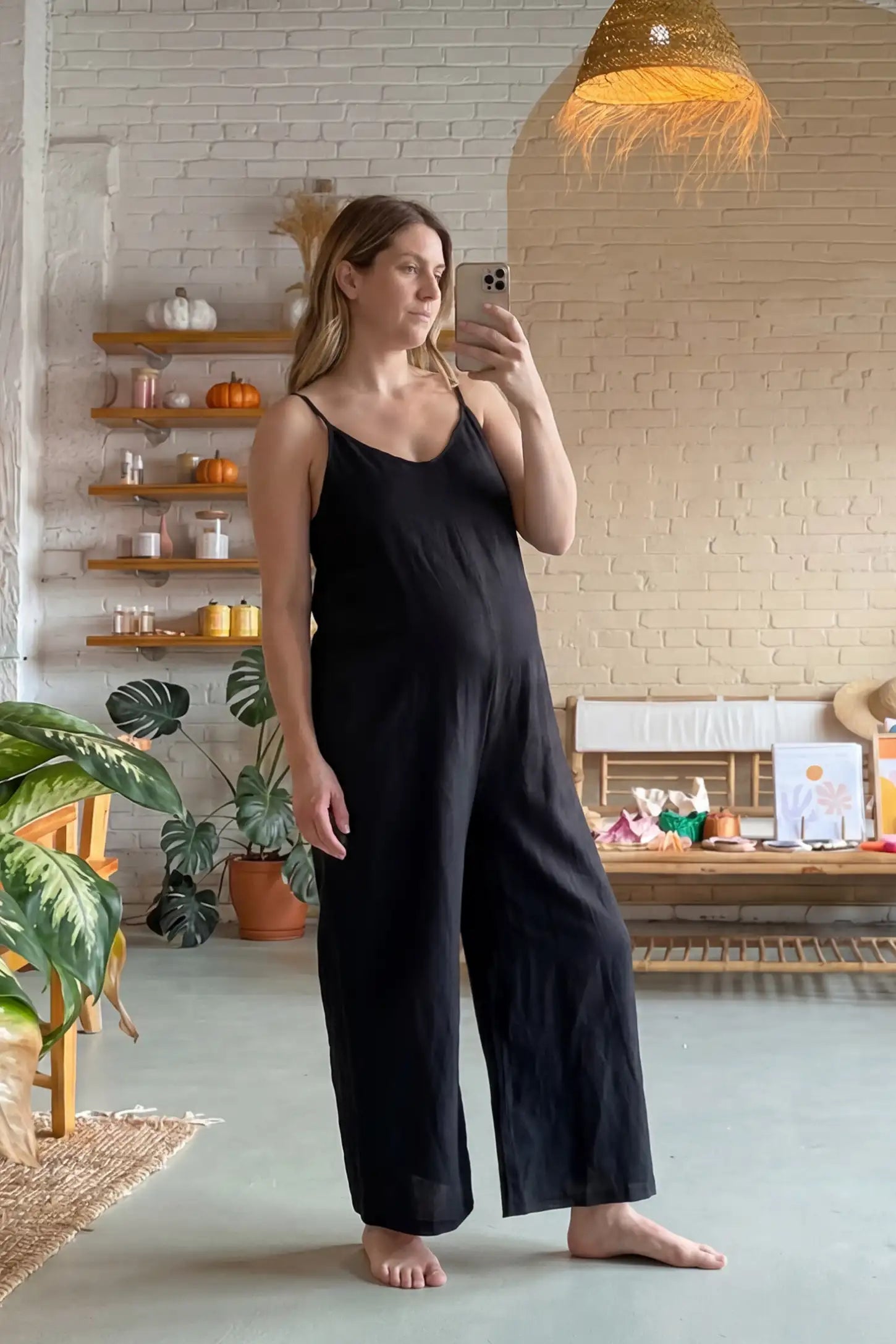 Wide‑Leg Scoop Neck Pocketed Maternity Jumpsuit Wide-leg scoop neck pocketed maternity jumpsuit in black with sleeveless design, thin strap, and wide-leg silhouette, UGC model