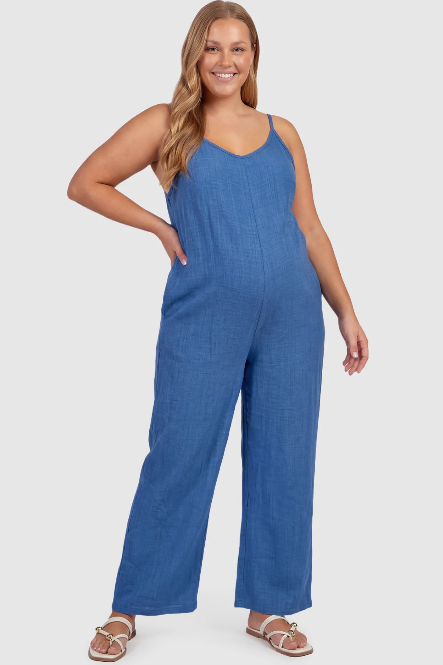 Wide‑Leg Scoop Neck Pocketed Maternity Jumpsuit Wide-leg scoop neck pocketed maternity jumpsuit in blue with sleeveless design, thin strap, and wide-leg silhouette, front view on plus-size model