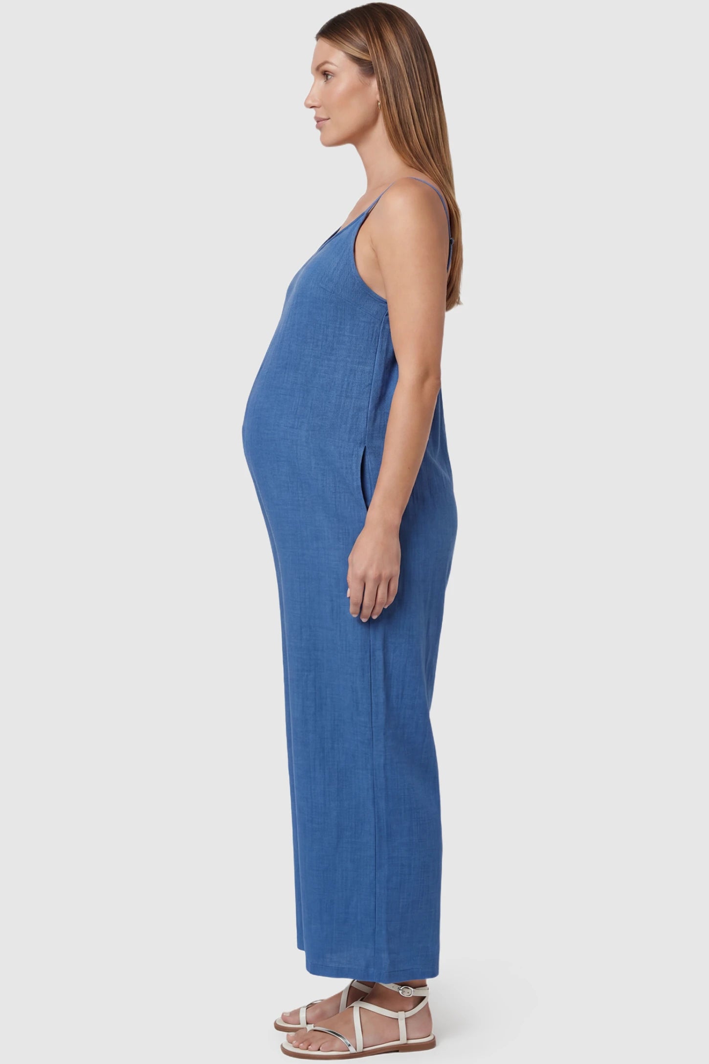 Wide‑Leg Scoop Neck Pocketed Maternity Jumpsuit Wide-leg scoop neck pocketed maternity jumpsuit in blue with sleeveless design, thin strap, and wide-leg silhouette, side view on pregnant model