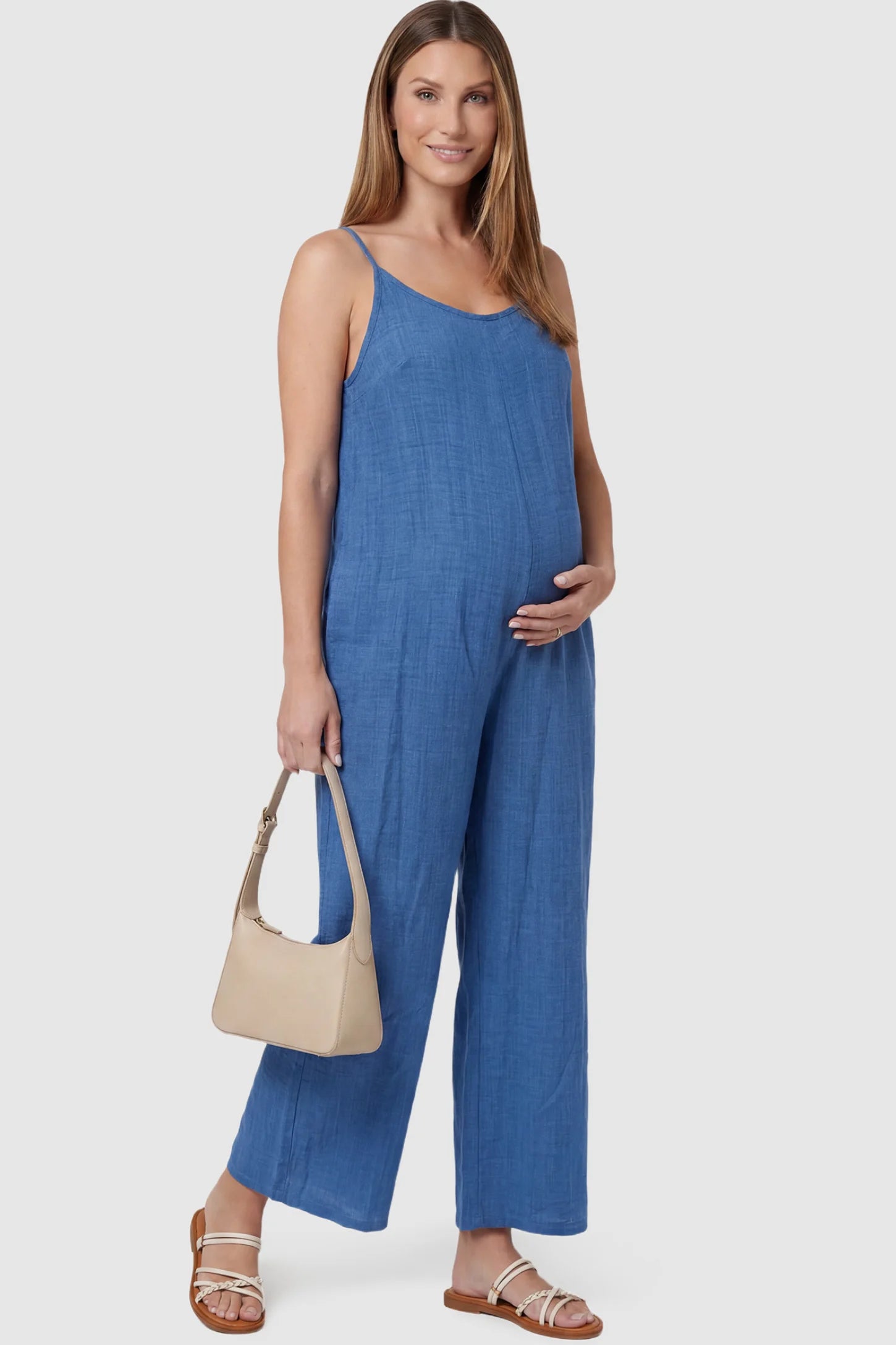 Wide‑Leg Scoop Neck Pocketed Maternity Jumpsuit Wide-leg scoop neck pocketed maternity jumpsuit in blue with sleeveless design, thin strap, and wide-leg silhouette, front view on pregnant model