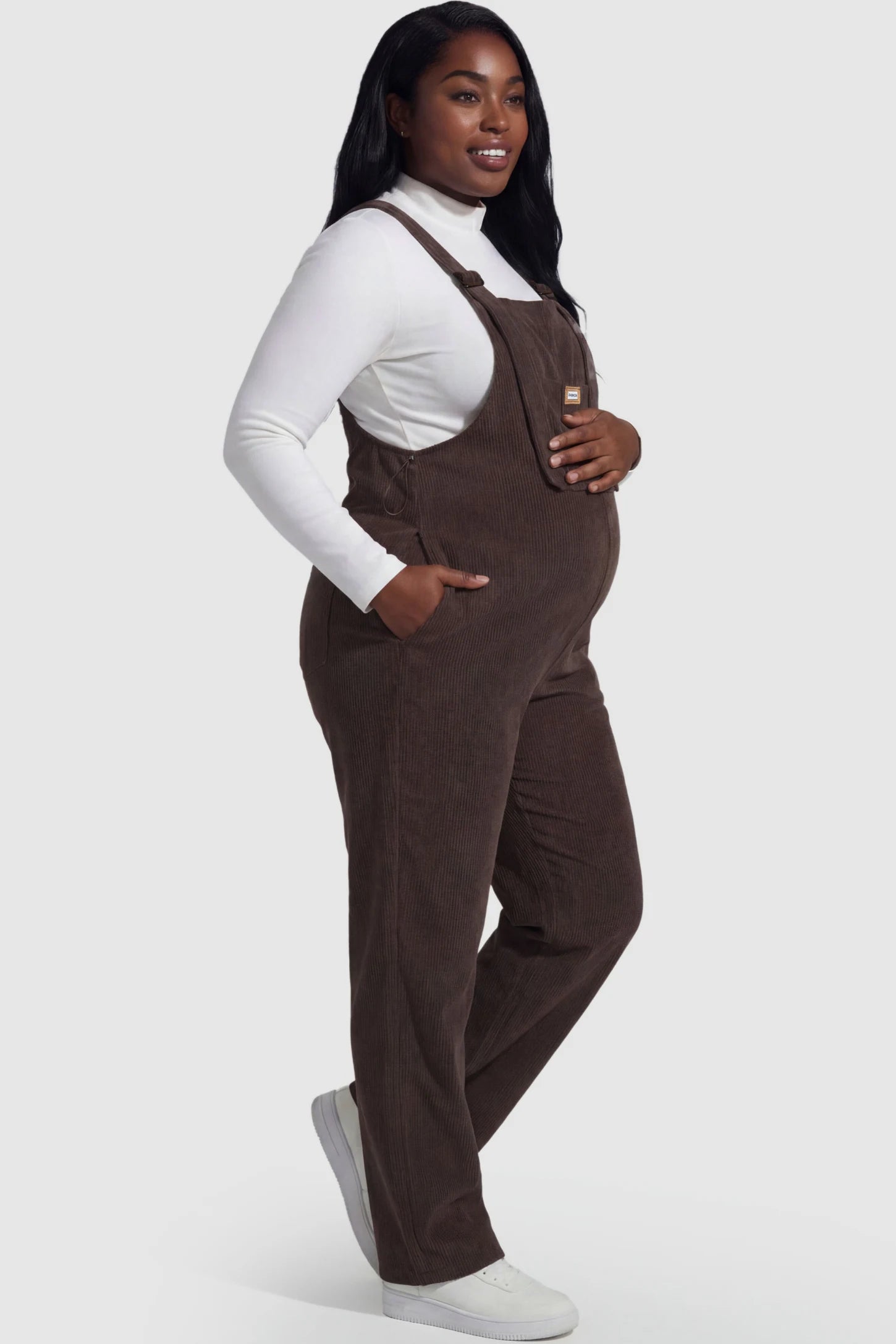 Wide Leg Side Stretch Panel Maternity Overalls Wide leg side stretch panel maternity overalls in brown featuring flexible side panels on a pregnant model