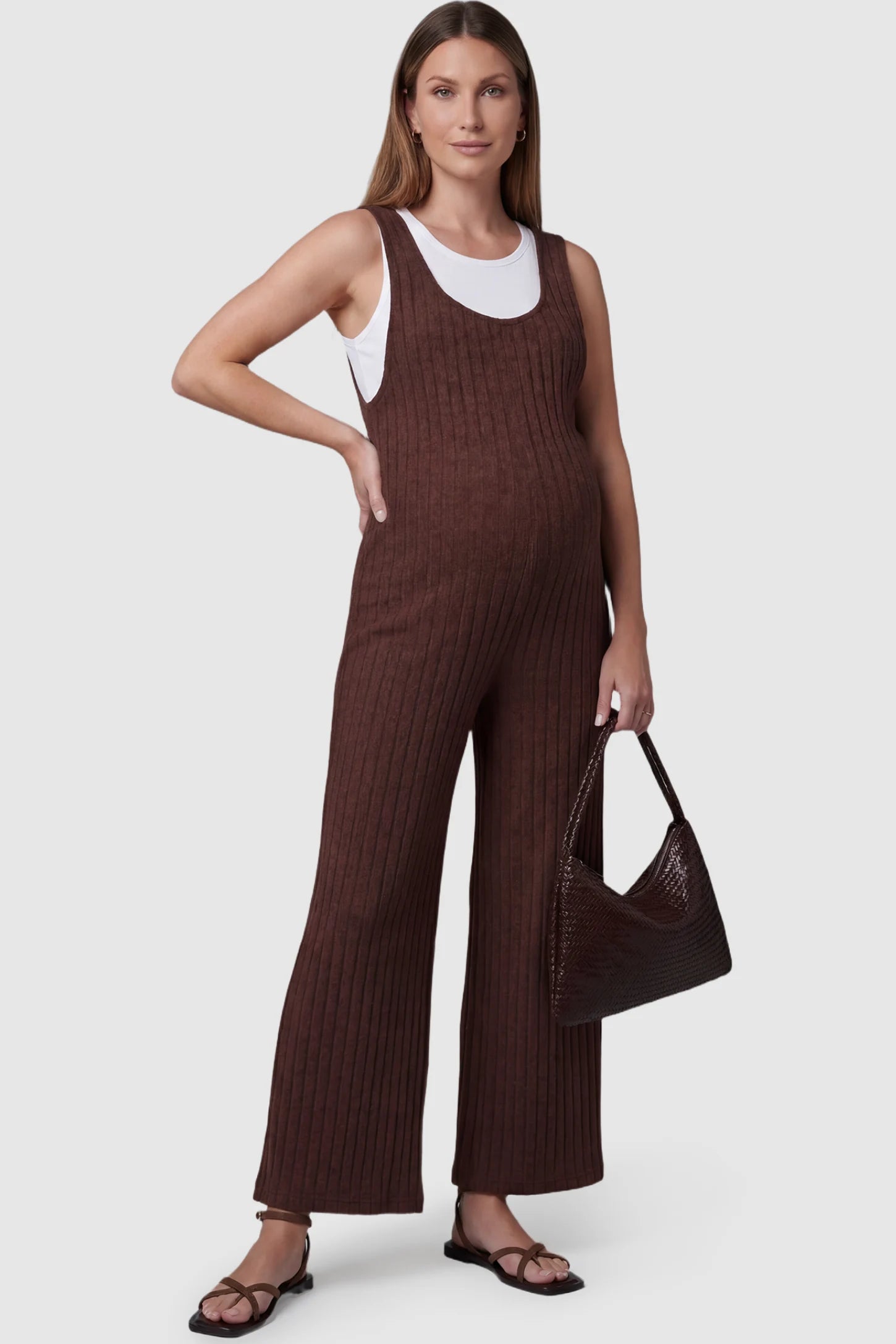 Ribbed Sleeveless Wide-Leg Maternity Jumpsuit Ribbed sleeveless wide-leg maternity jumpsuit in dark brown with sleeveless ribbed design, front view on pregnant model