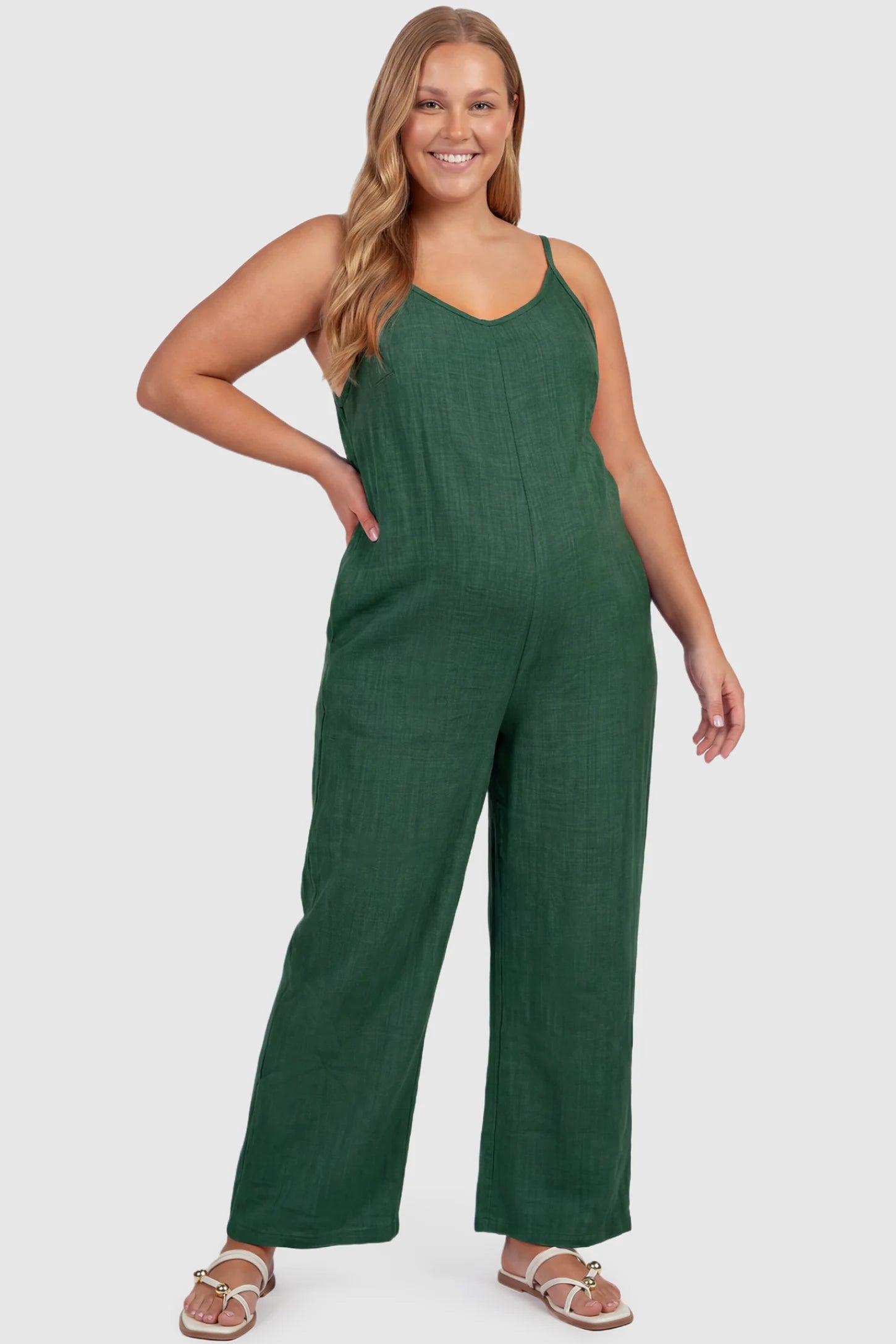 Wide‑Leg Scoop Neck Pocketed Maternity Jumpsuit Wide-leg scoop neck pocketed maternity jumpsuit in green with sleeveless design, thin strap, and wide-leg silhouette, front view on plus-size model