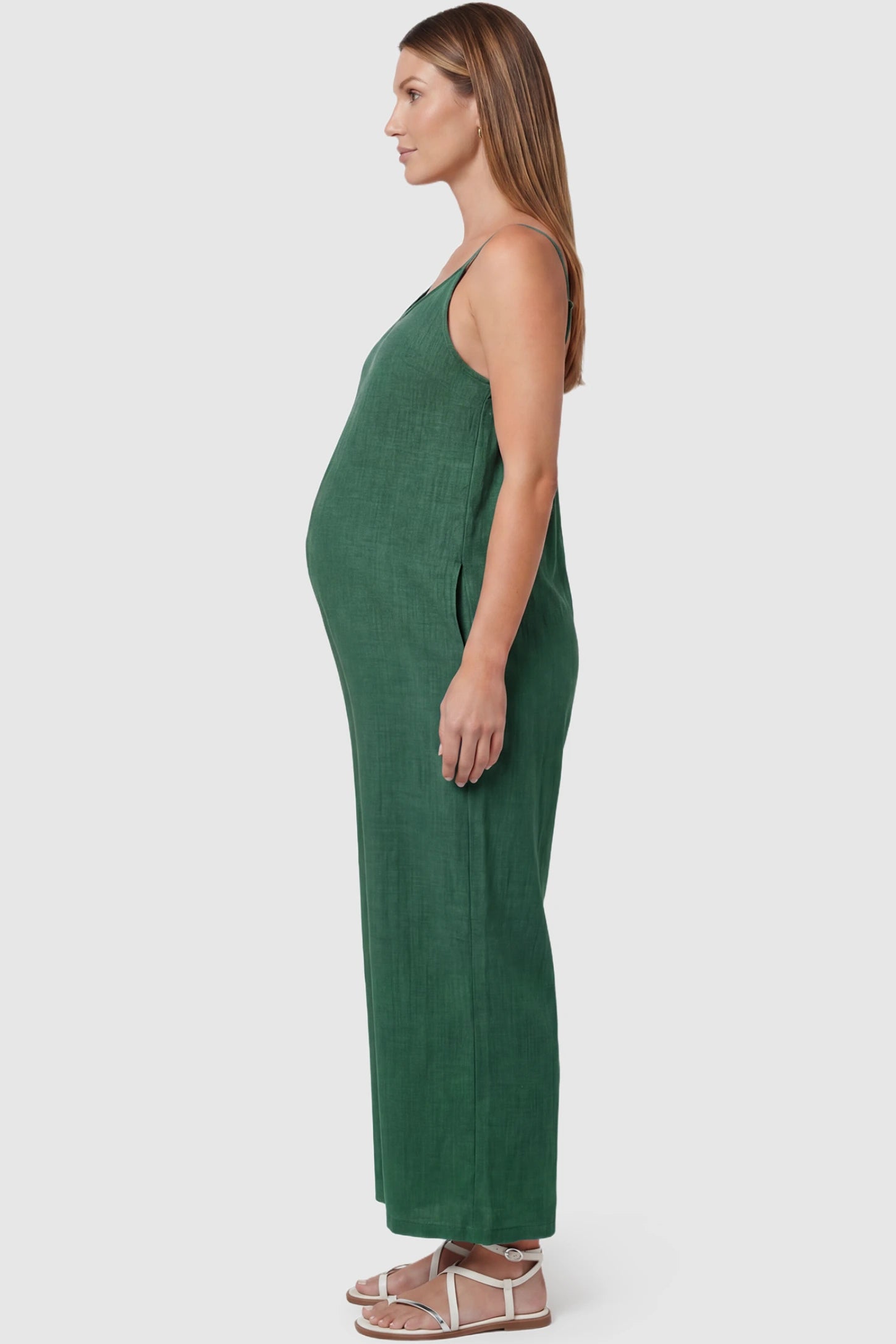 Wide‑Leg Scoop Neck Pocketed Maternity Jumpsuit Wide-leg scoop neck pocketed maternity jumpsuit in green with sleeveless design, thin strap, and wide-leg silhouette, side view on pregnant model