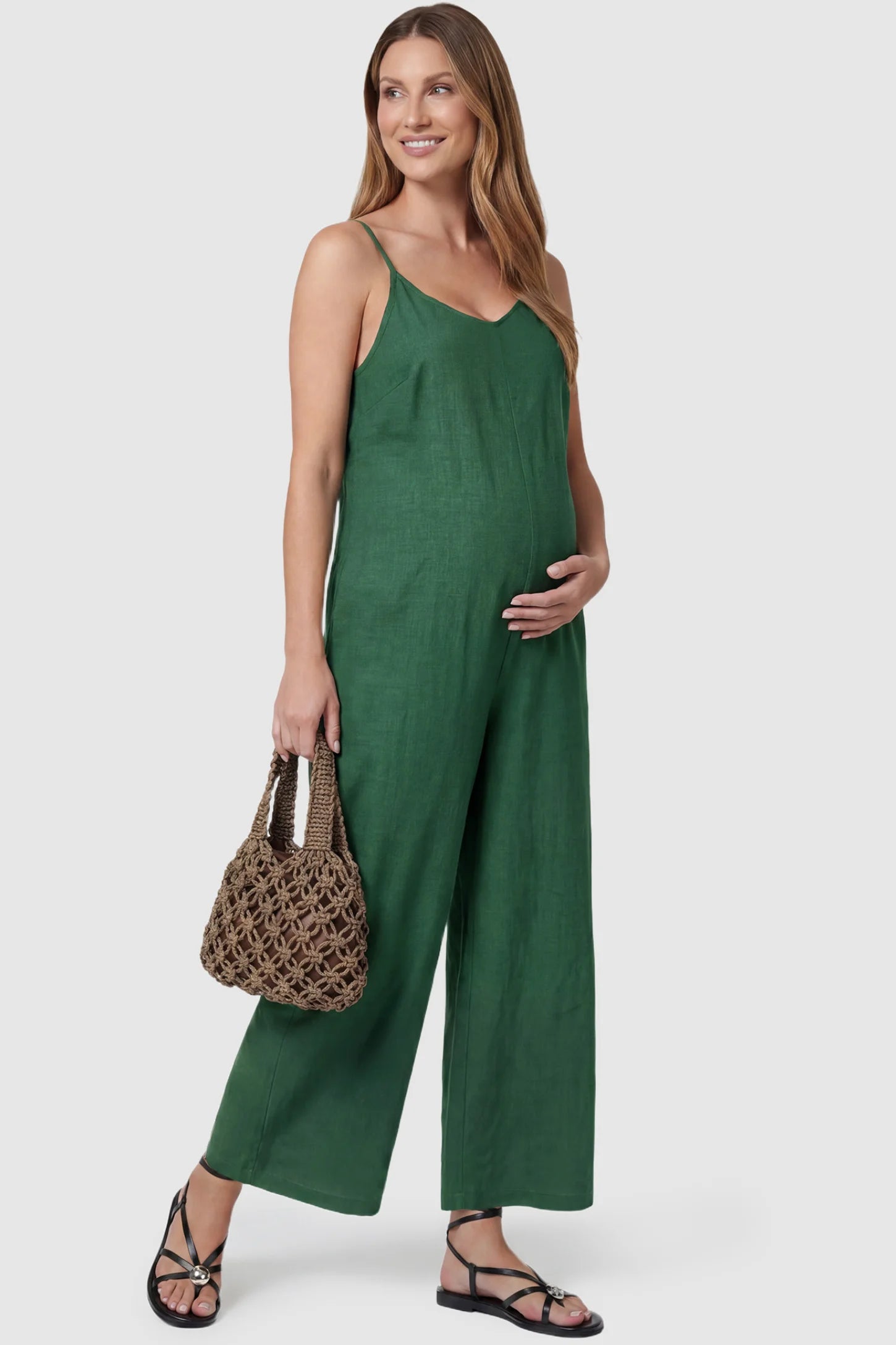 Wide‑Leg Scoop Neck Pocketed Maternity Jumpsuit Wide-leg scoop neck pocketed maternity jumpsuit in green with sleeveless design, thin strap, and wide-leg silhouette, side view on pregnant model