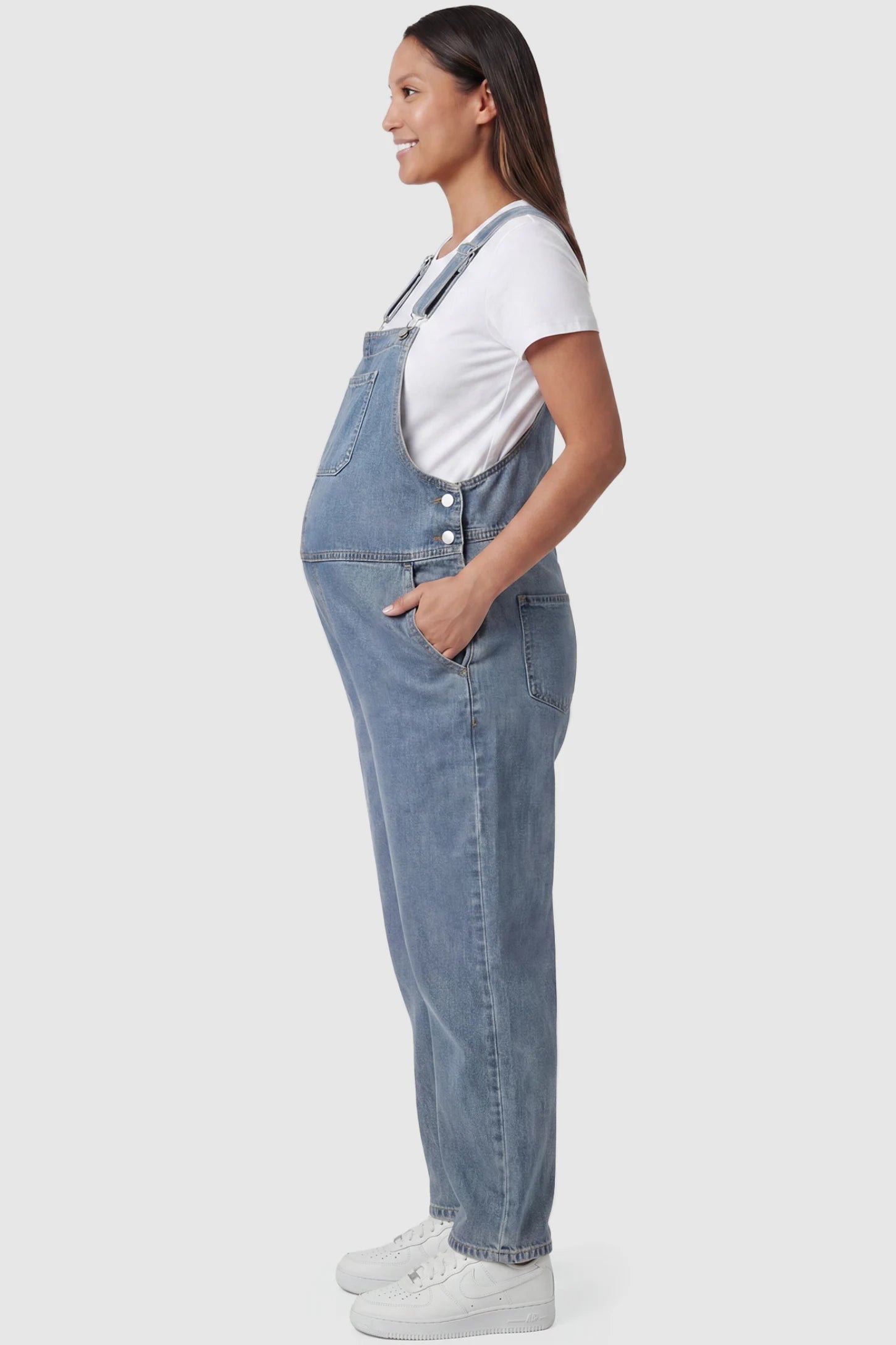 Wide leg relaxed fit maternity overalls in light blue with side pockets, side view on pregnant model