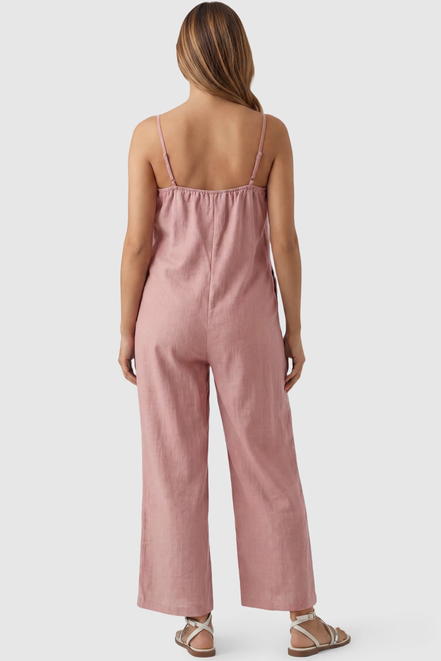 Wide‑Leg Scoop Neck Pocketed Maternity Jumpsuit Wide-leg scoop neck pocketed maternity jumpsuit in pink with sleeveless design, thin strap, and wide-leg silhouette, back view on pregnant model