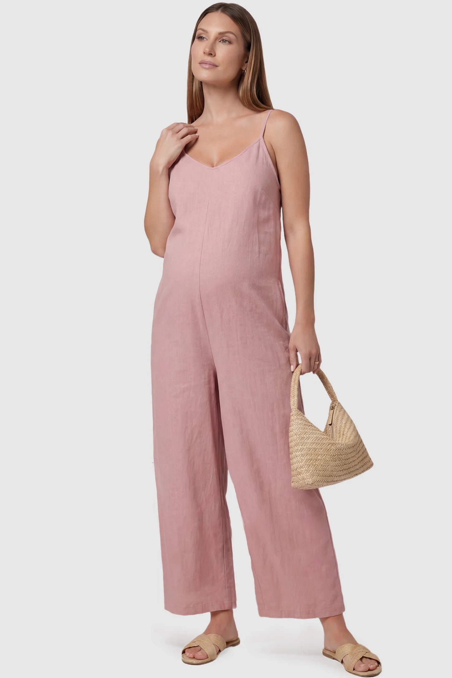 Wide‑Leg Scoop Neck Pocketed Maternity Jumpsuit Wide-leg scoop neck pocketed maternity jumpsuit in pink with sleeveless design, thin strap, and wide-leg silhouette, front view on pregnant model
