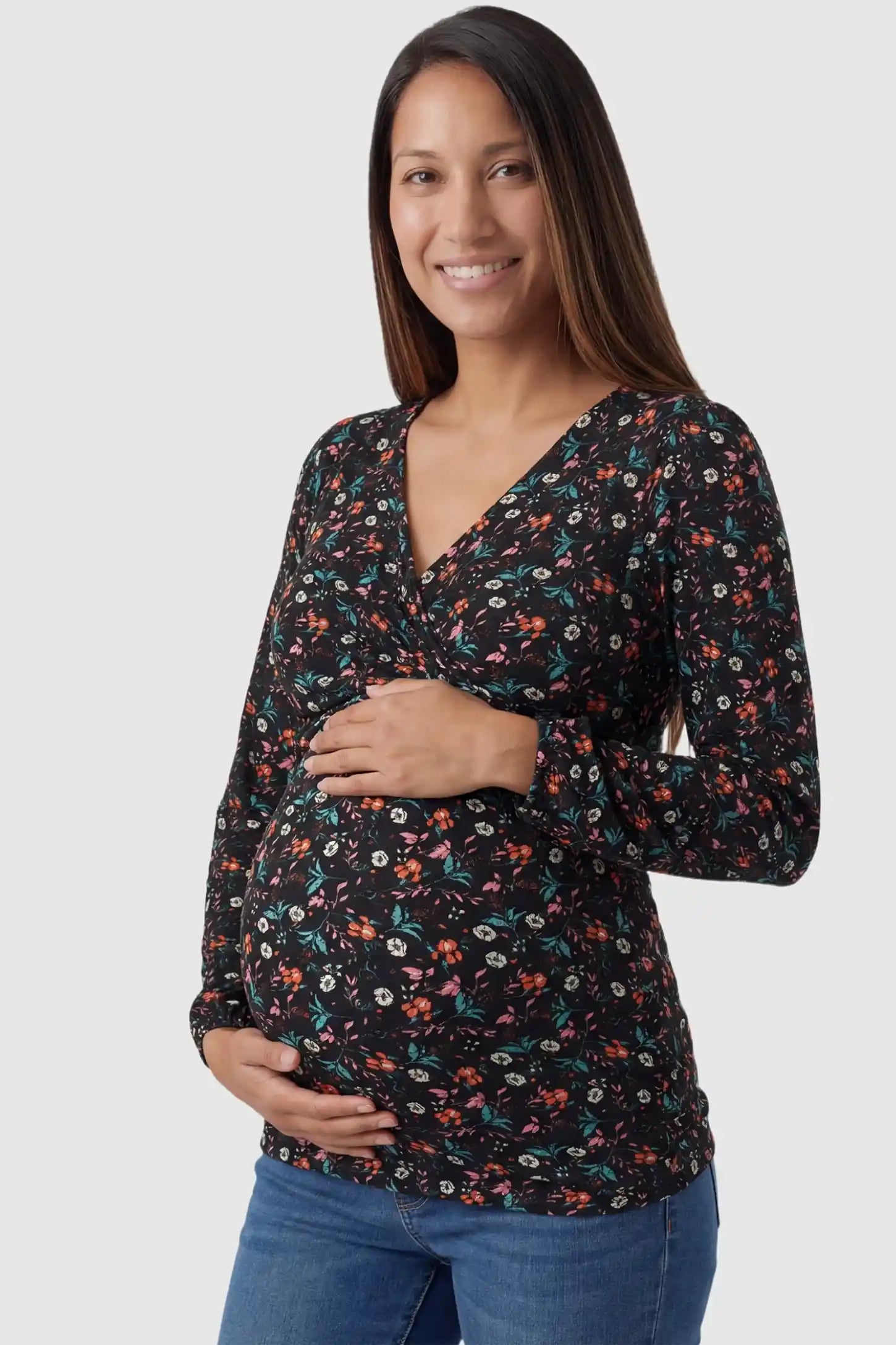 Floral Nursing Access Long Sleeve Maternity & Nursing Blouse in black floral print featuring a crossover neckline on a pregnant model in front view