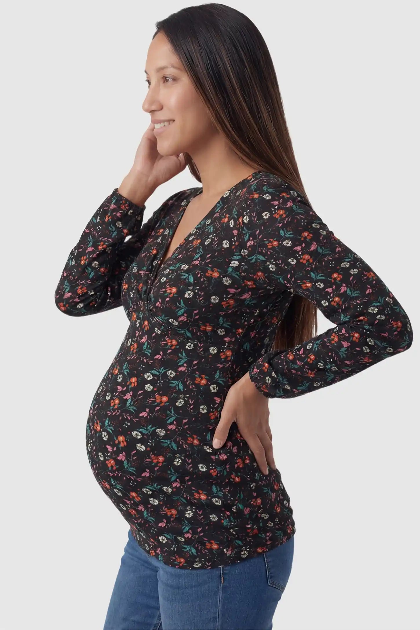 Floral Nursing Access Long Sleeve Maternity & Nursing Blouse in black floral print featuring a crossover neckline on a pregnant model in side view.
