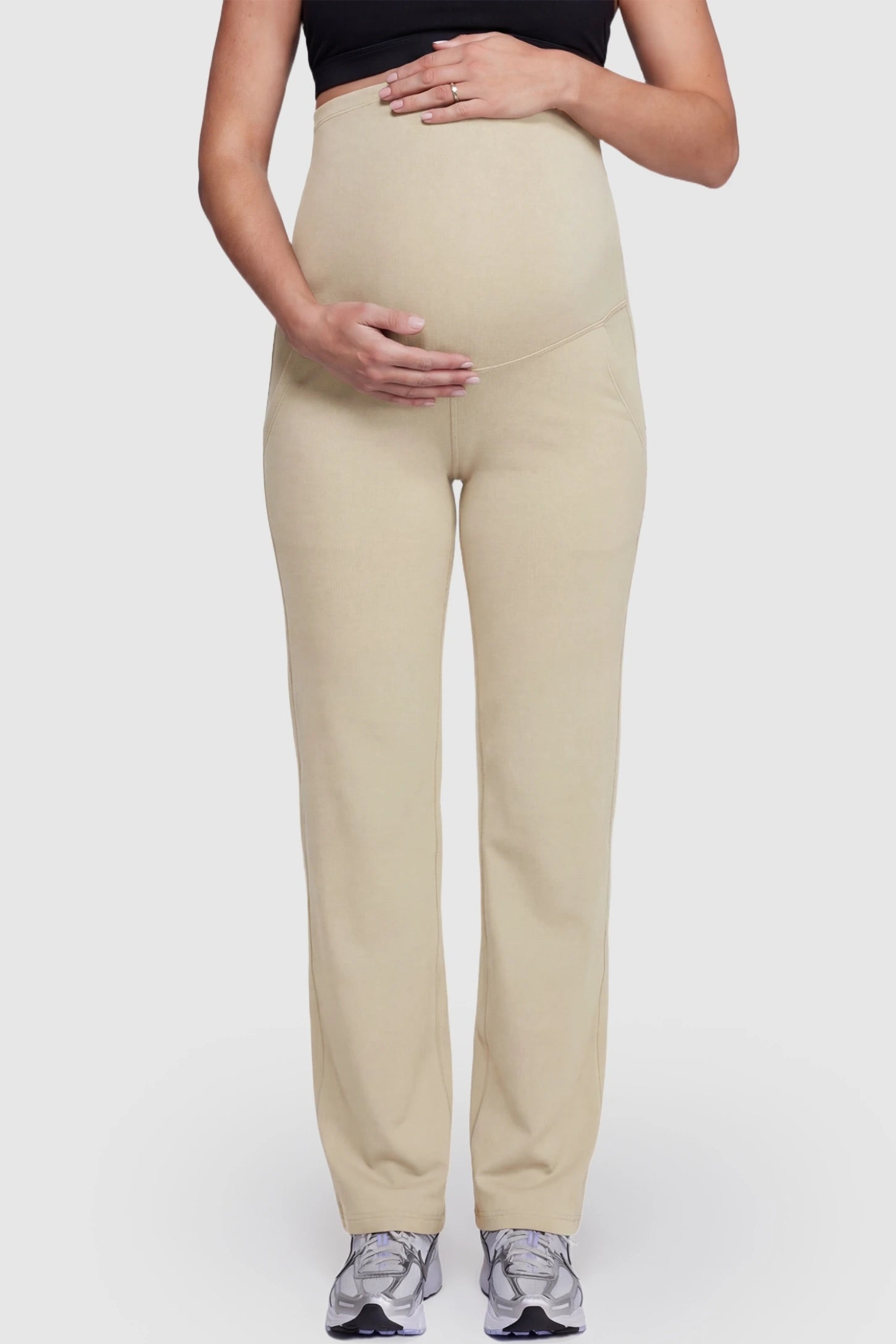 Suede-finish high-waisted straight leg yoga maternity pants in beige with belly support band, front view on pregnant model